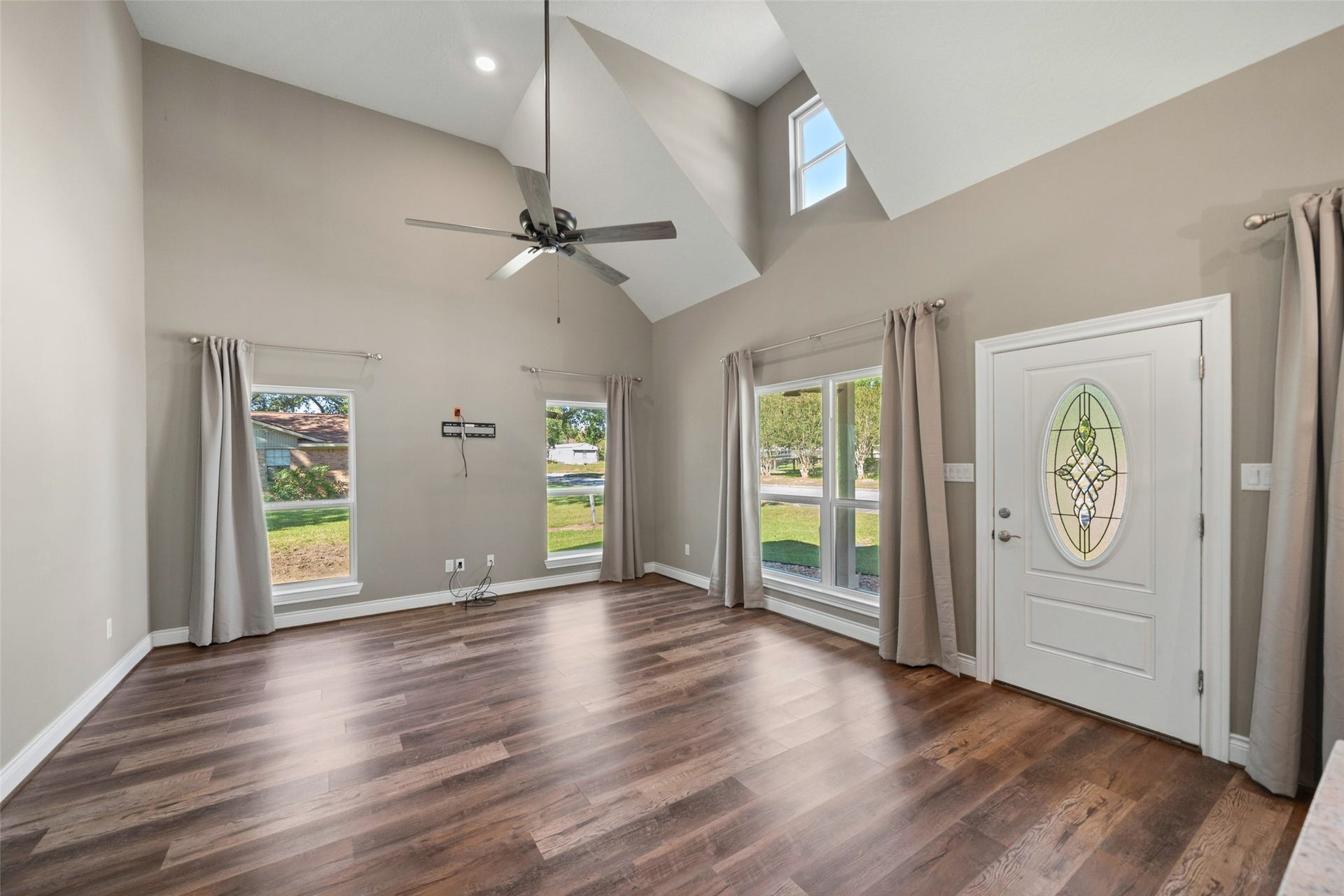 1125 Galveston Street, Hempstead, TX 77445 Living area featuring a high ceiling, ceiling fan, wood-look flooring, and double entry doors with decorative glass.