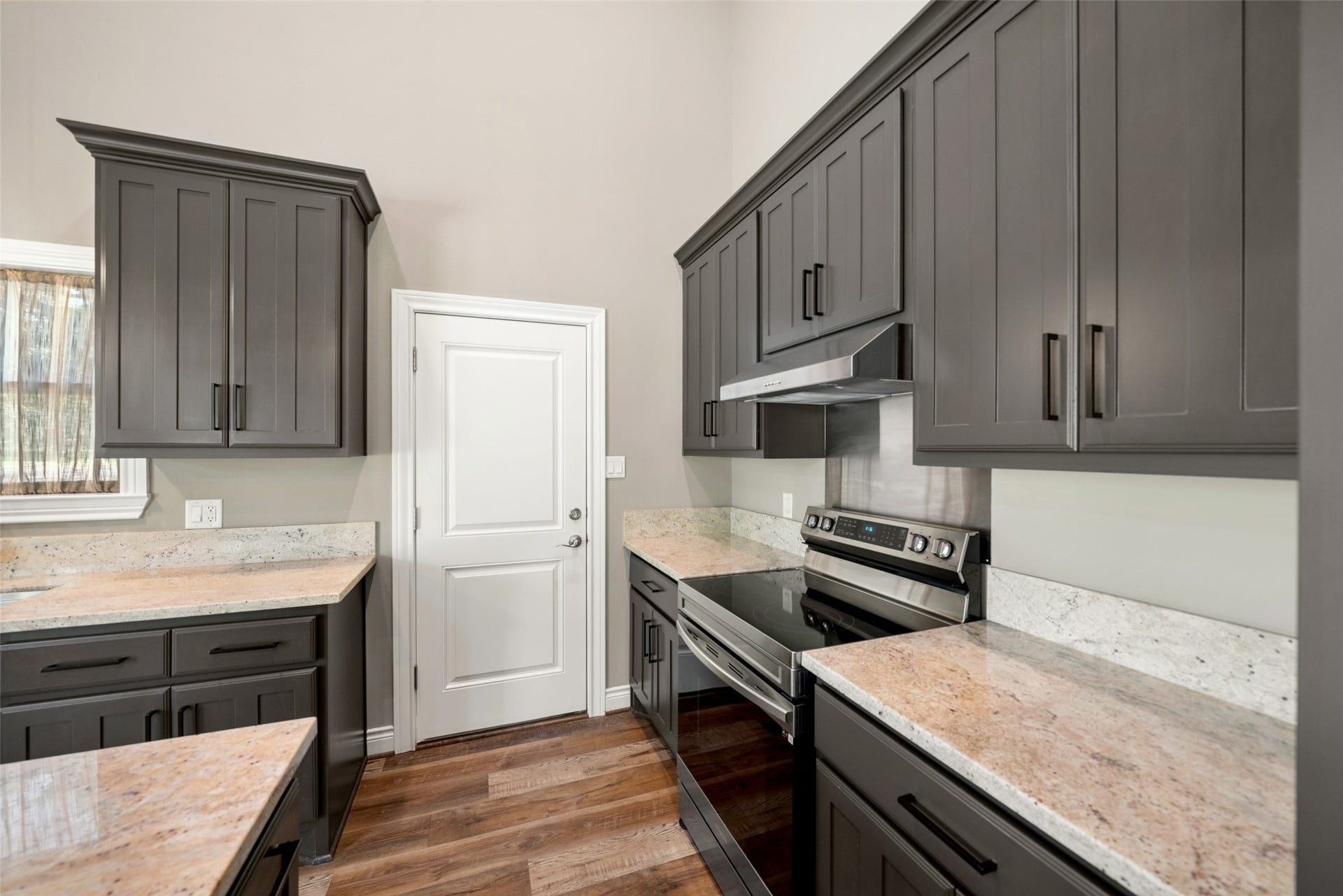 1125 Galveston Street, Hempstead, TX 77445 Kitchen featuring dark cabinetry, light countertops, stainless steel appliances, and wood-look flooring.