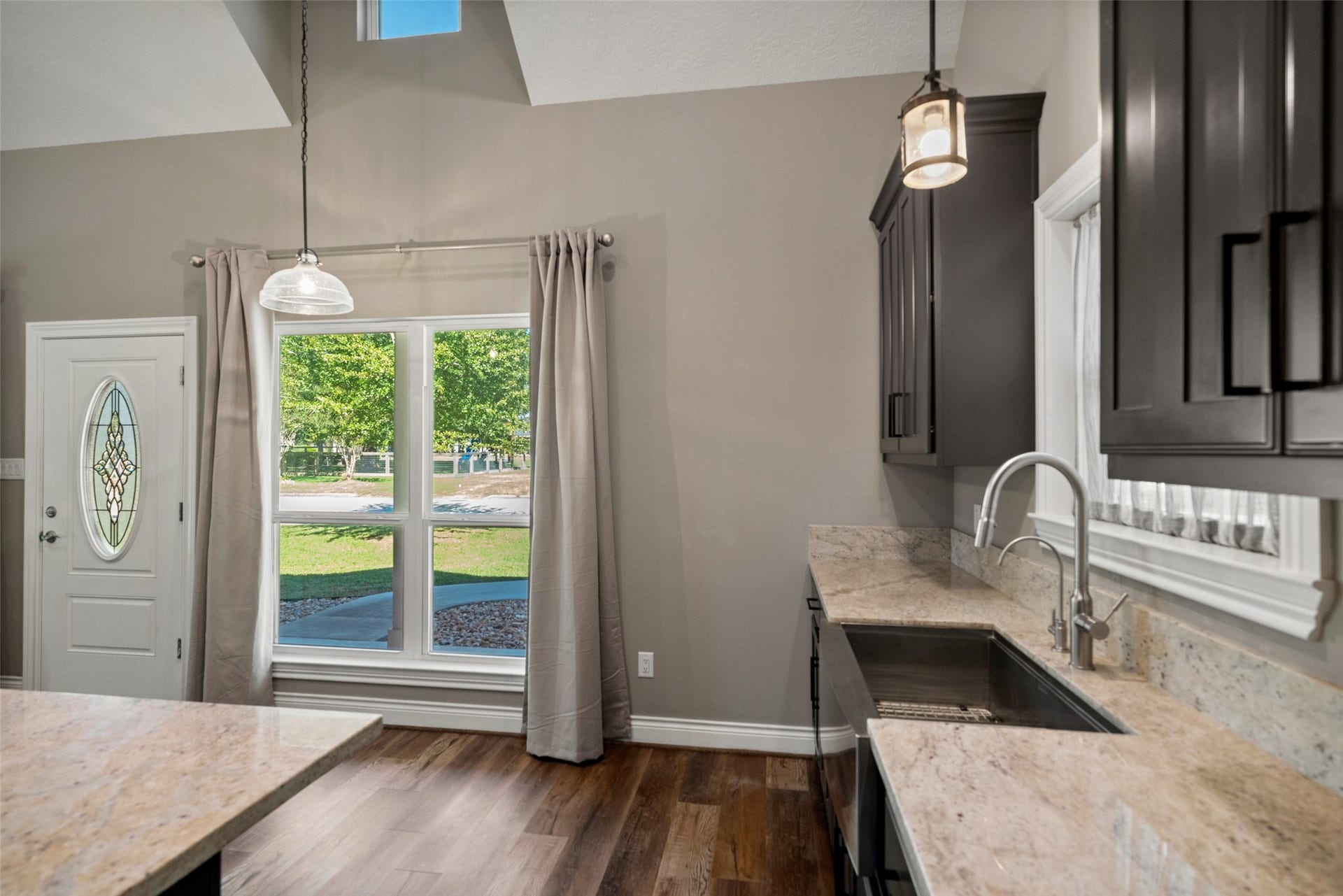 1125 Galveston Street, Hempstead, TX 77445 Kitchen view highlighting dark cabinetry, light countertops, pendant lighting, and adjacent windows overlooking the yard.