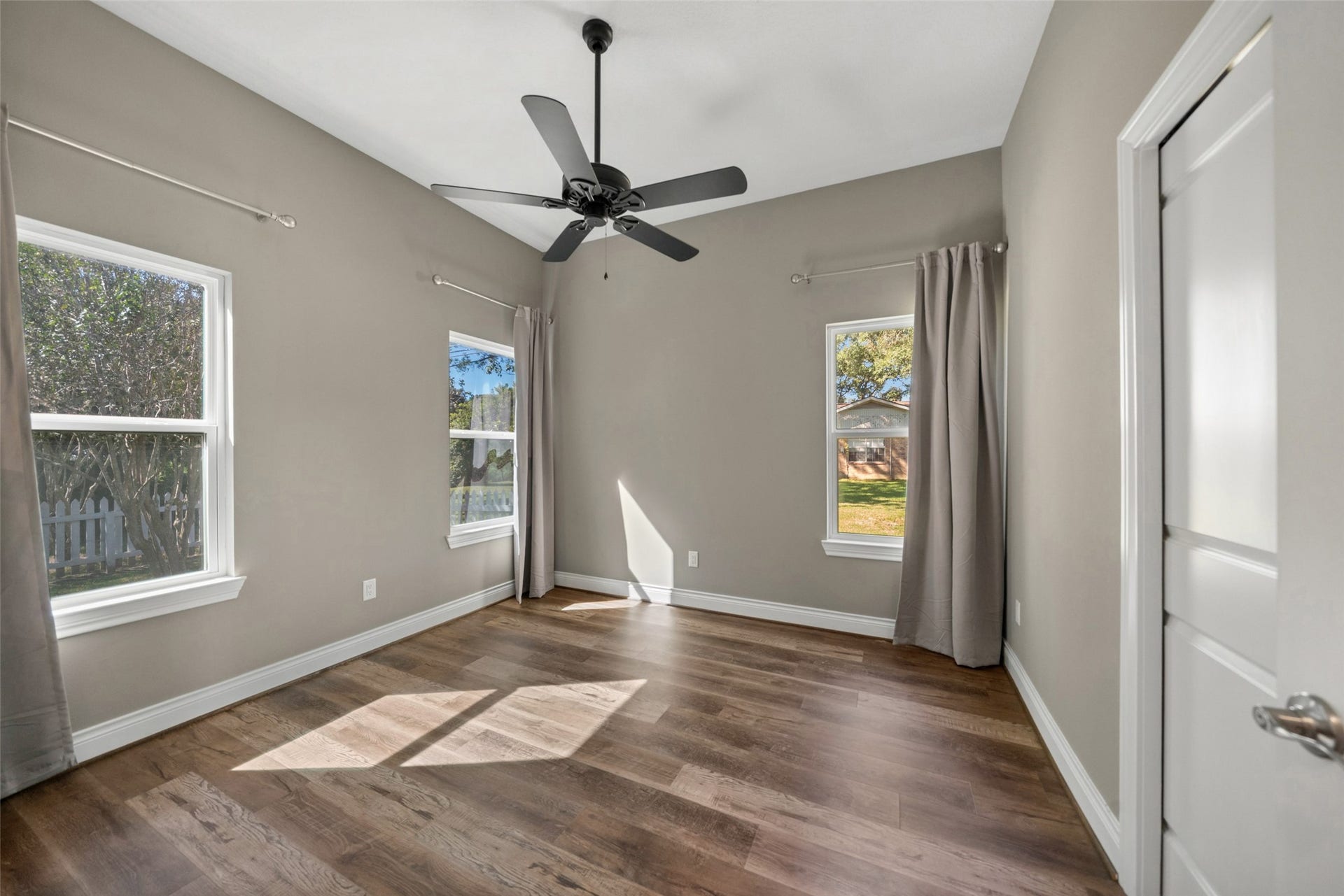 1125 Galveston Street, Hempstead, TX 77445 Bedroom featuring a tray ceiling, ceiling fan, wood-look flooring, multiple windows, and closet access.