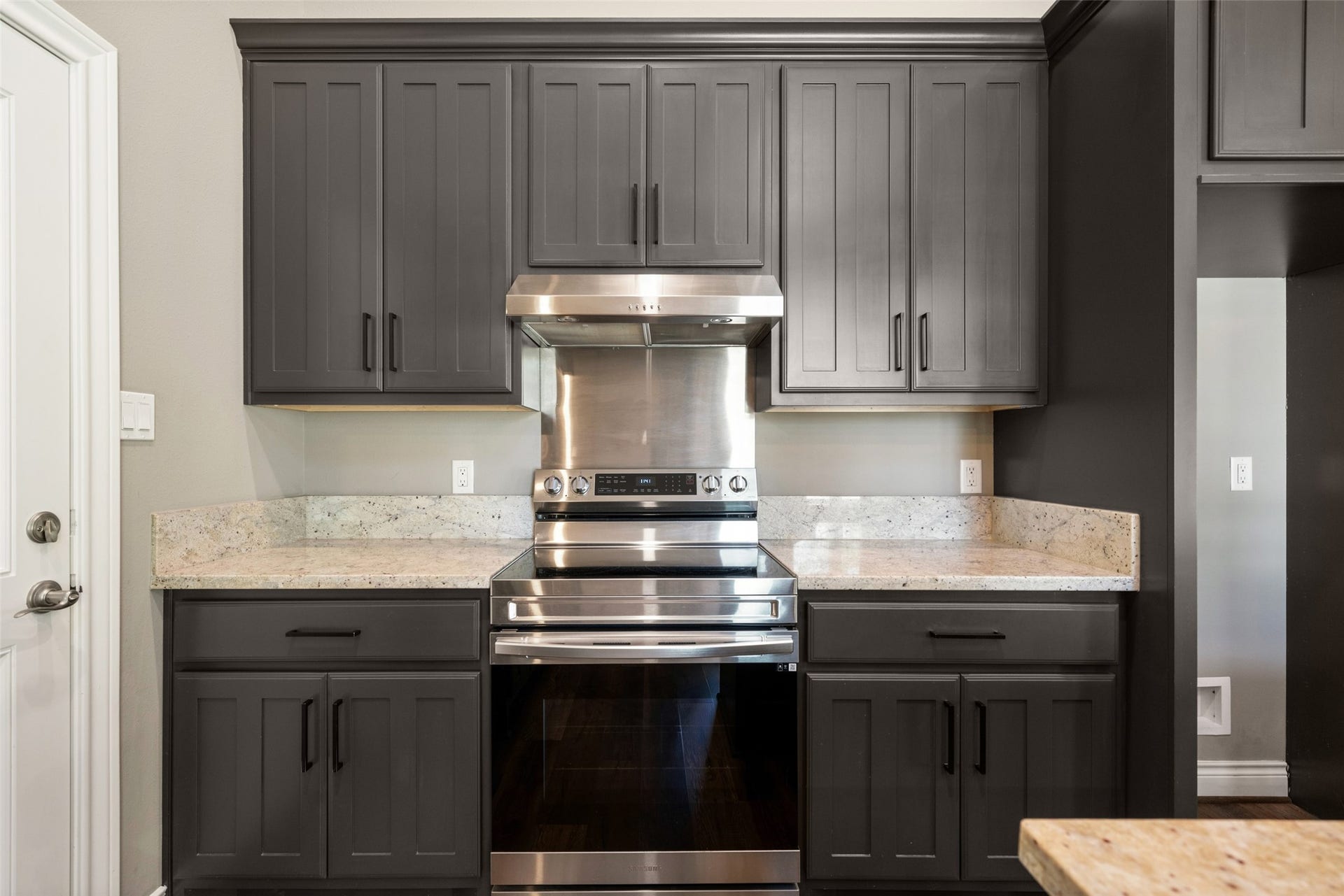 1125 Galveston Street, Hempstead, TX 77445 Kitchen featuring white cabinetry, a stainless steel range and vent hood, tile backsplash, and a window above the sink.