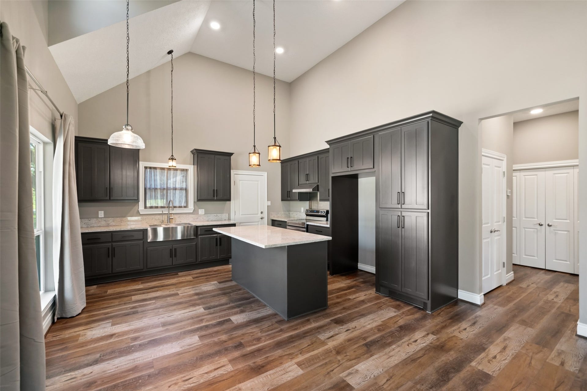 1125 Galveston Street, Hempstead, TX 77445 Kitchen featuring a center island, dark cabinetry, stainless steel appliances, pendant lighting, and a vaulted ceiling