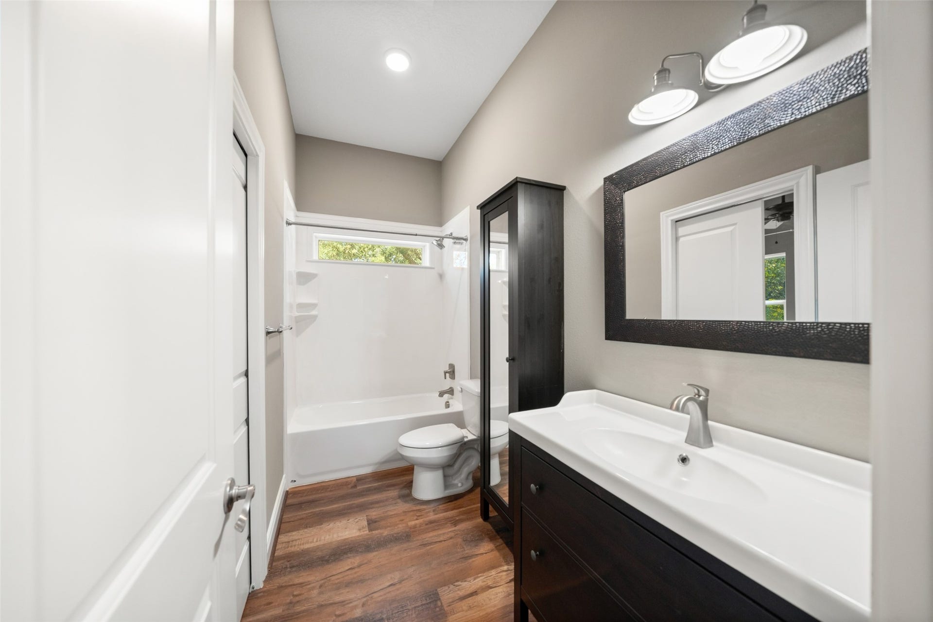 1125 Galveston Street, Hempstead, TX 77445 Bathroom featuring a long vanity with dark cabinetry, a framed mirror, and a tub/shower combination