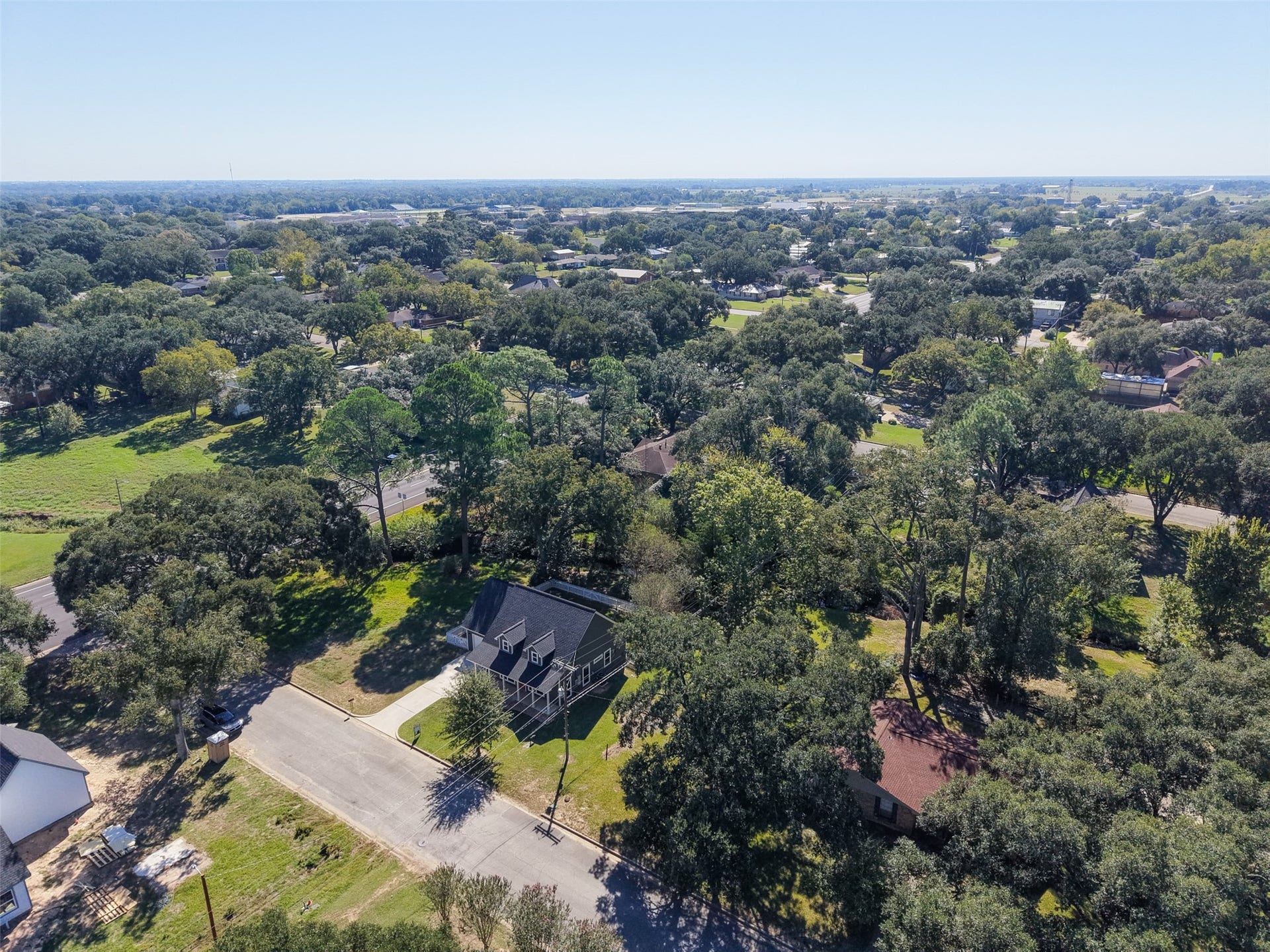 1125 Galveston Street, Hempstead, TX 77445 Wide aerial perspective highlighting the wooded surroundings and neighborhood beyond the home.