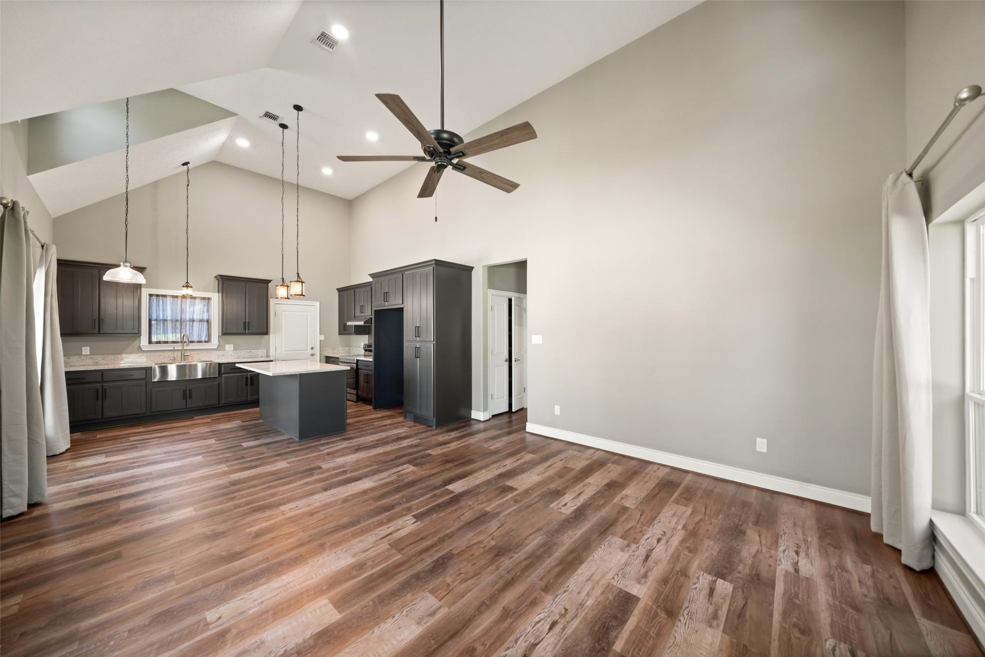 1125 Galveston Street, Hempstead, TX 77445 Open living and kitchen area with wood-look flooring, a ceiling fan, and recessed lighting.