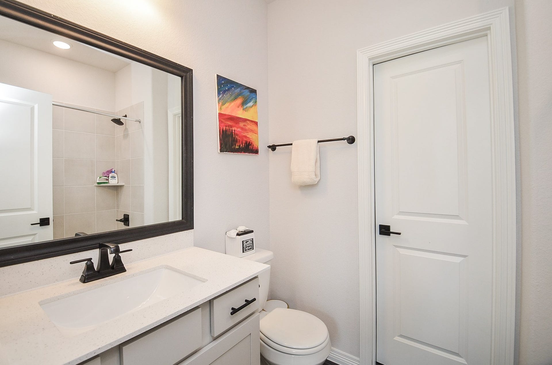 30706 Hawthorn Glen Court, Fulshear, TX 77441 Modern bathroom featuring a sleek vanity with a large framed mirror, elegant fixtures, and a tiled shower for a contemporary touch.
