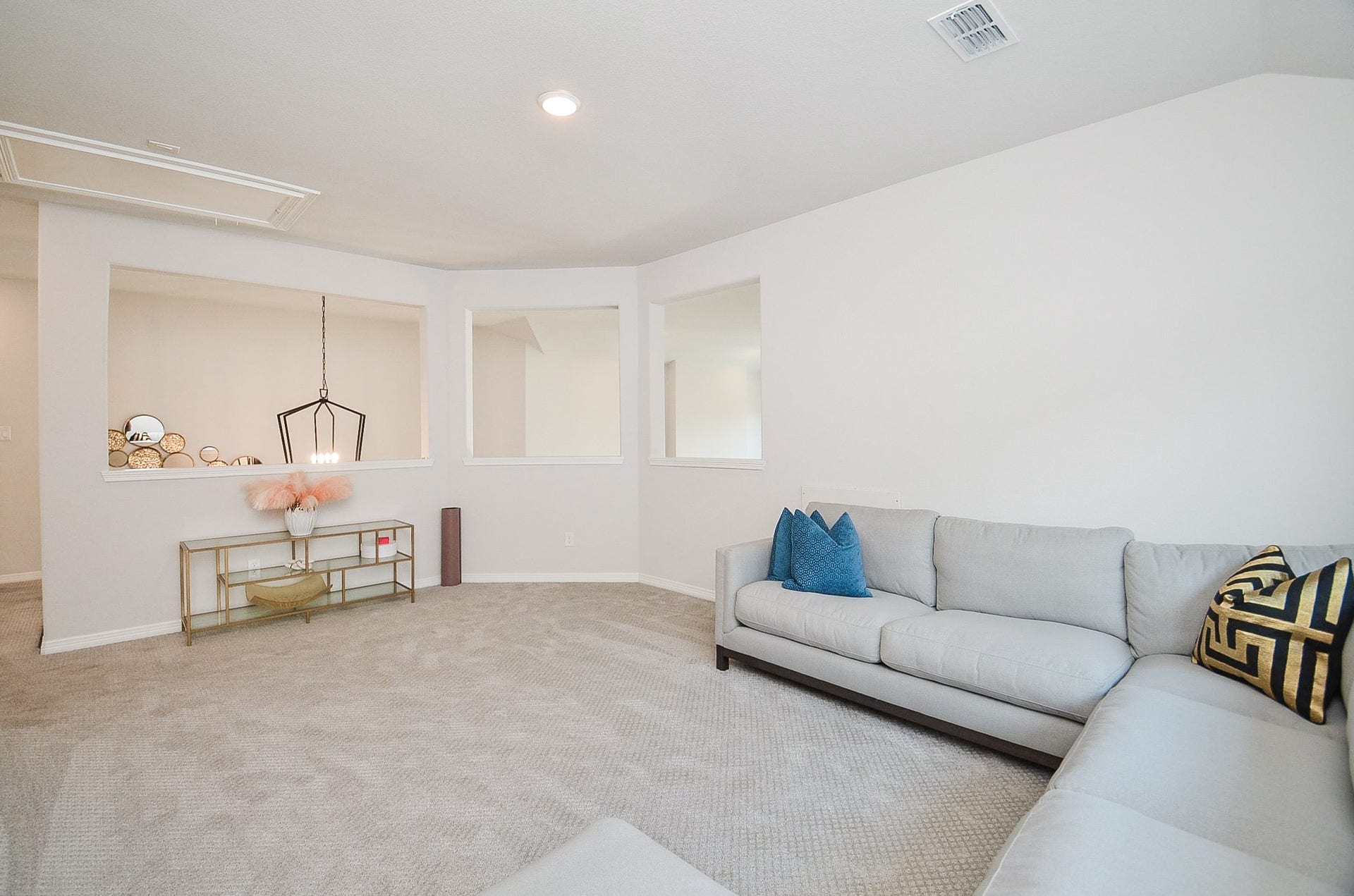 30706 Hawthorn Glen Court, Fulshear, TX 77441 Spacious living area with plush carpeting, modern sectional sofa, and elegant decorative accents, offering a cozy and inviting atmosphere.