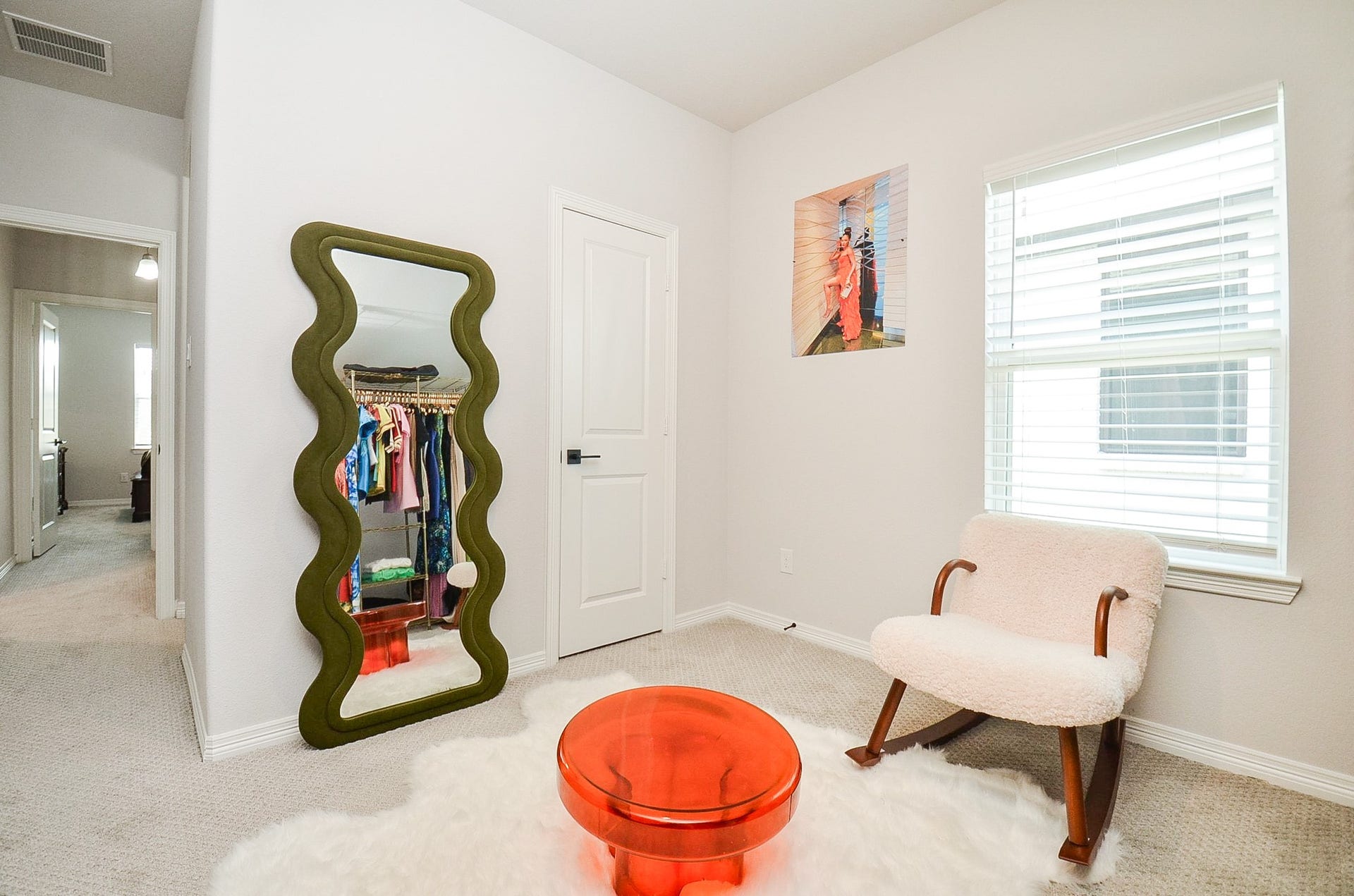 30706 Hawthorn Glen Court, Fulshear, TX 77441 Chic and cozy corner features a stylish wave mirror, plush chair, and vibrant decor, creating a welcoming and modern atmosphere.