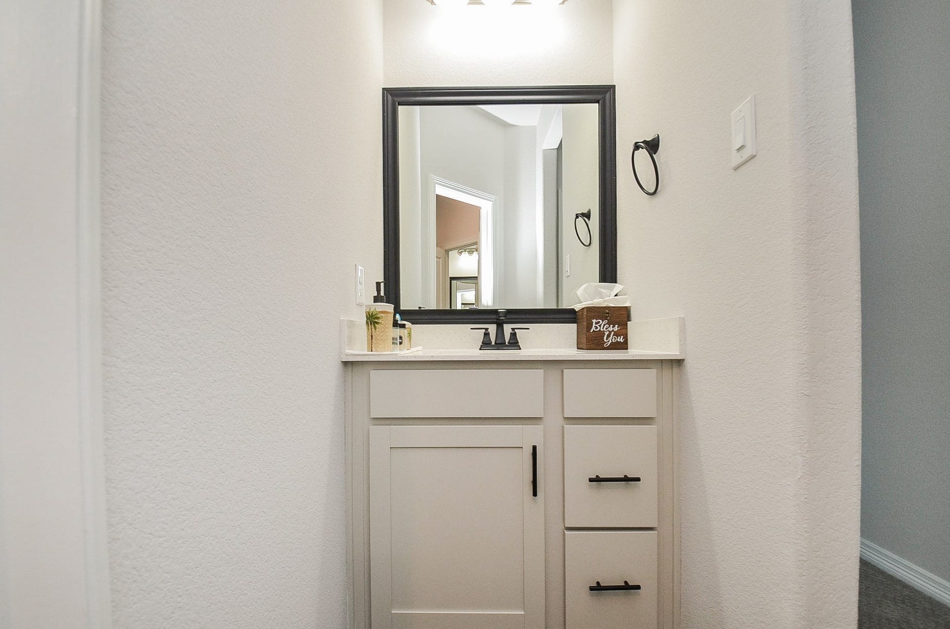 30706 Hawthorn Glen Court, Fulshear, TX 77441 Charming powder room with a sleek vanity, modern fixtures, and a stylish framed mirror.
