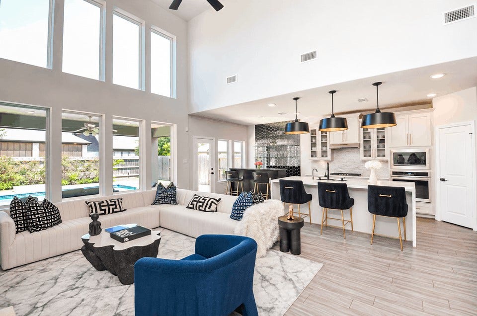30706 Hawthorn Glen Court, Fulshear, TX 77441 Stunning open-concept living space with soaring ceilings and abundant natural light, featuring a modern kitchen with a chic breakfast bar, stylish pendant lighting, and a cozy living area perfect for entertaining.