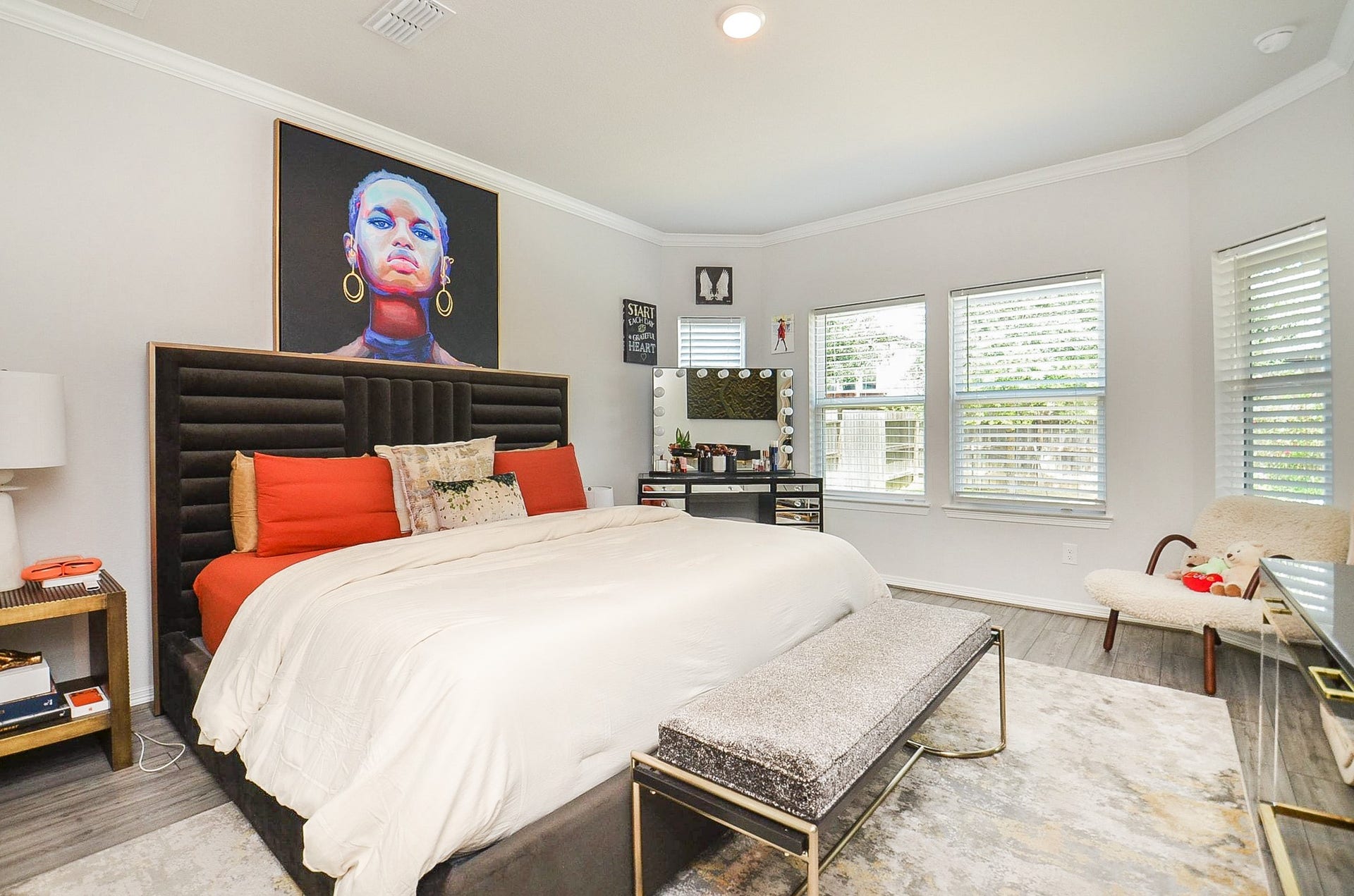 30706 Hawthorn Glen Court, Fulshear, TX 77441 Spacious and stylish bedroom featuring a plush bed with bold accents, modern decor, and abundant natural light from multiple windows.