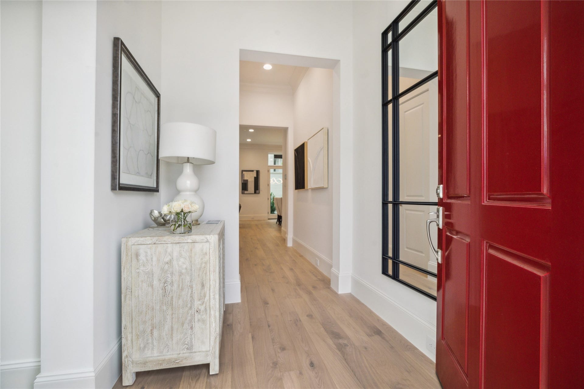7 Wentworth Gate Path, Houston, TX 77027 Step into this bright and welcoming formal entry. The first floor living space features 11-foot ceilings, Legno Bastone engineered White Oak wood floors, and designer light fixtures. **Photo is of another home in the community and for information purposes only. Buyer to verify all details.**
