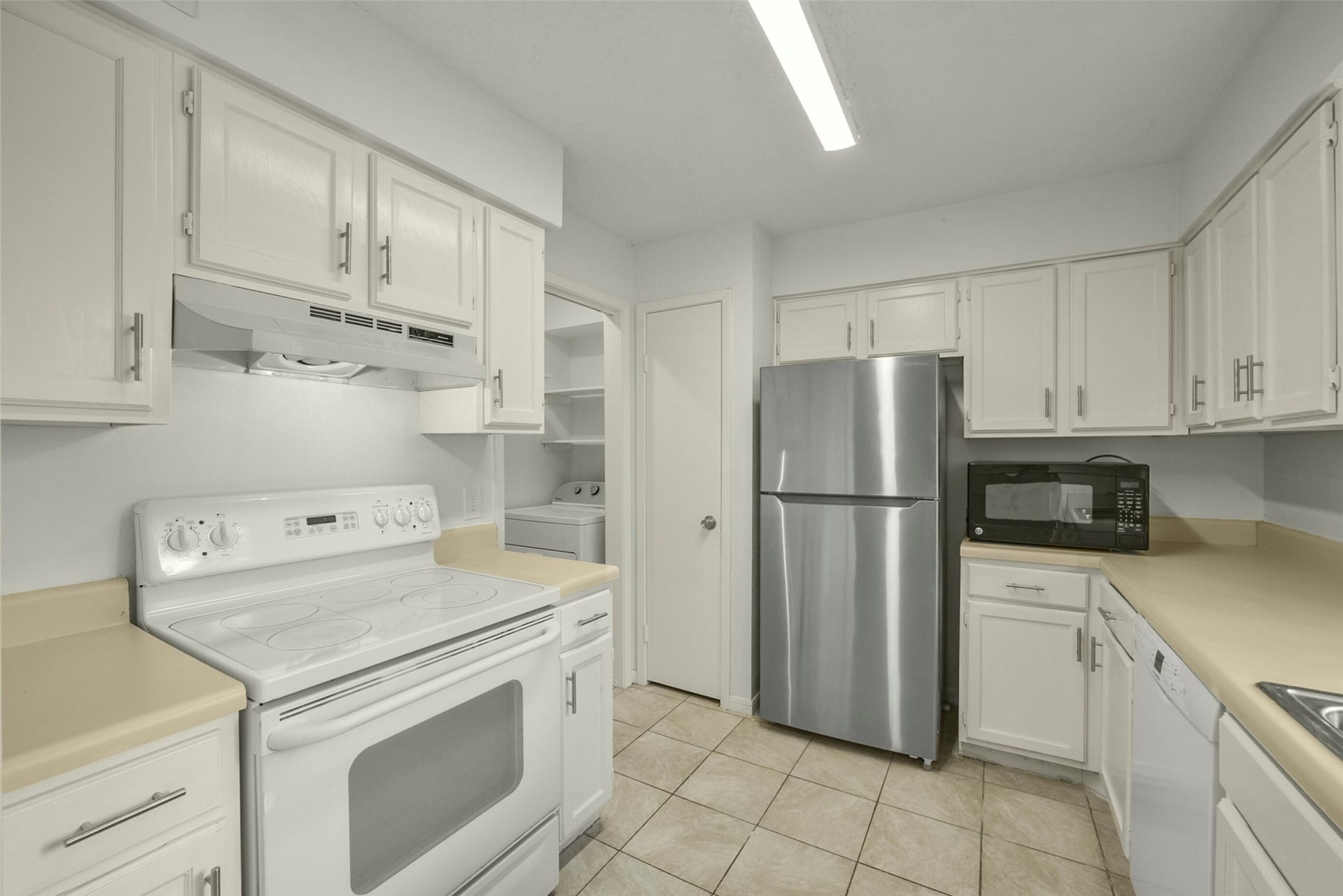 The kitchen offers plenty of counter and cabinet space. Notice fresh paint throughout.