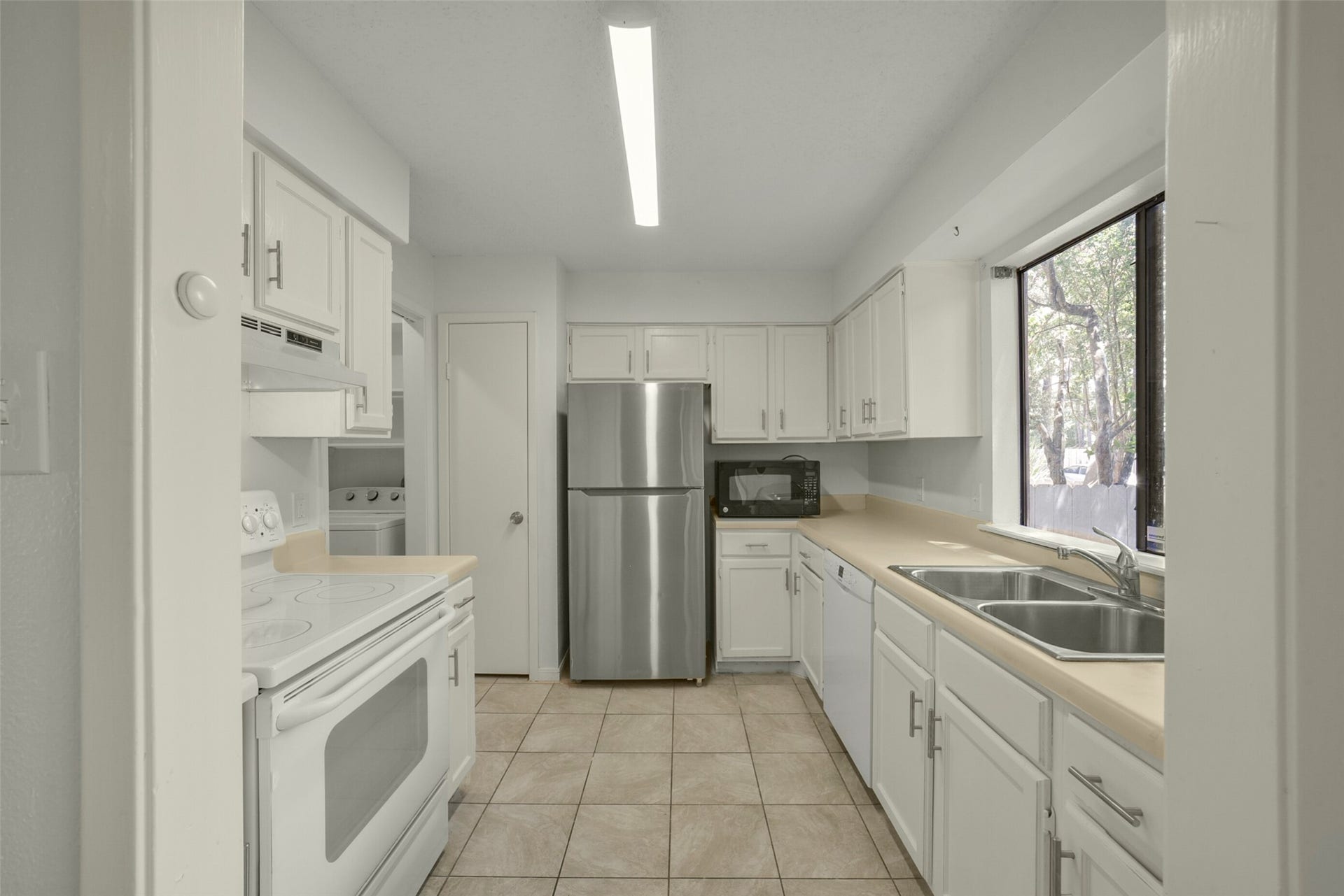 he kitchen offers plenty of counter and cabinet space. Notice fresh paint throughout.