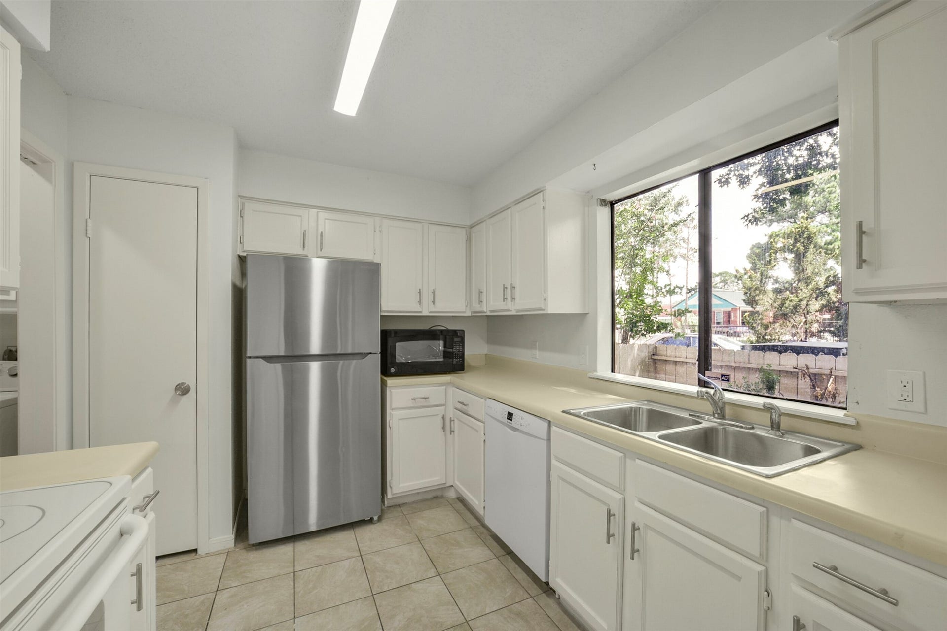 The kitchen offers plenty of counter and cabinet space. Notice fresh paint throughout.