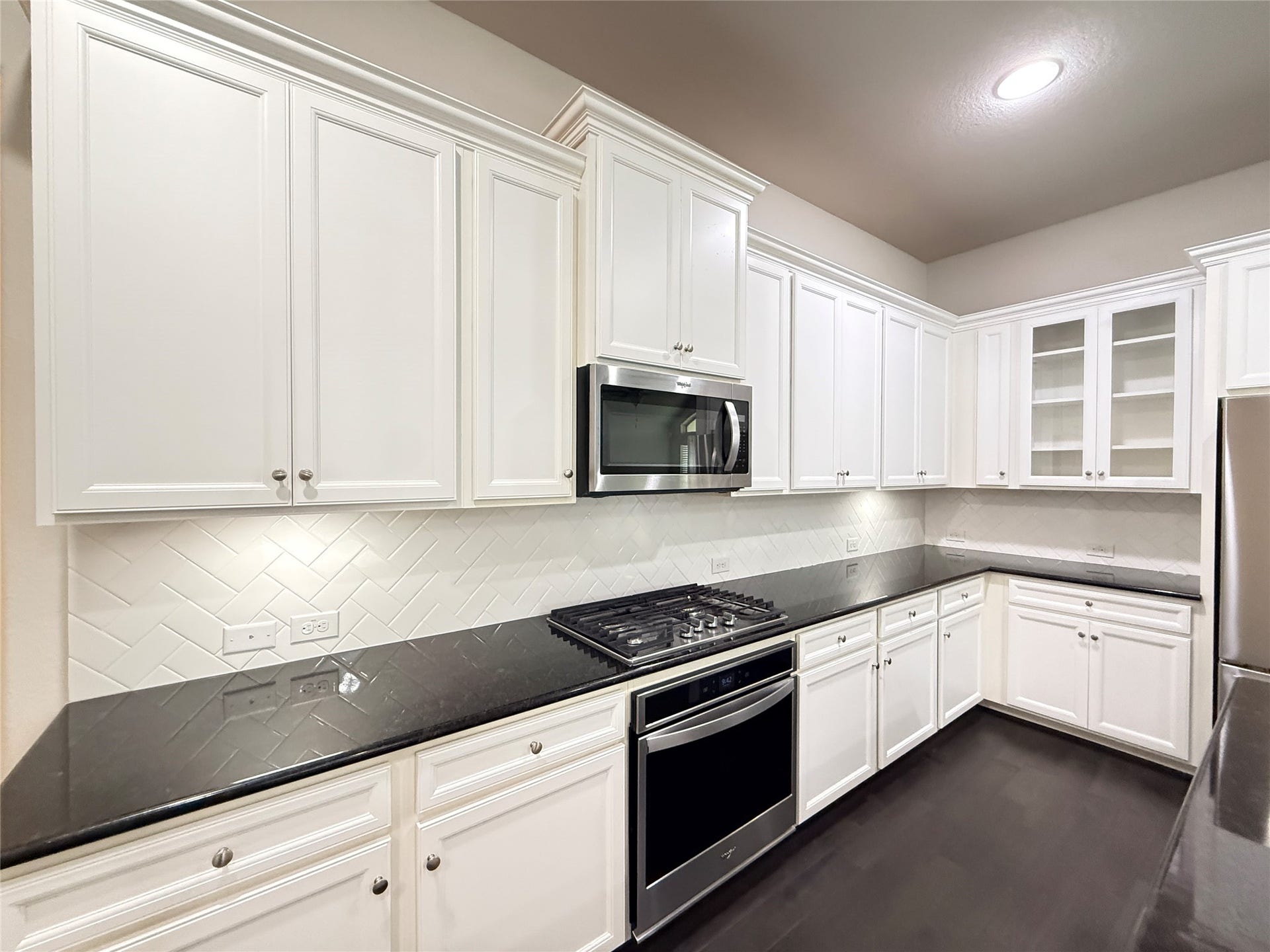 20635 Riley Copper Drive, Cypress, TX 77433 Tall cabinets with undermount lighting, beautiful granite countertops and sparkling stainless steel appliances. The upgraded cabinets are 42" with glass mullions next to the refrigerator.