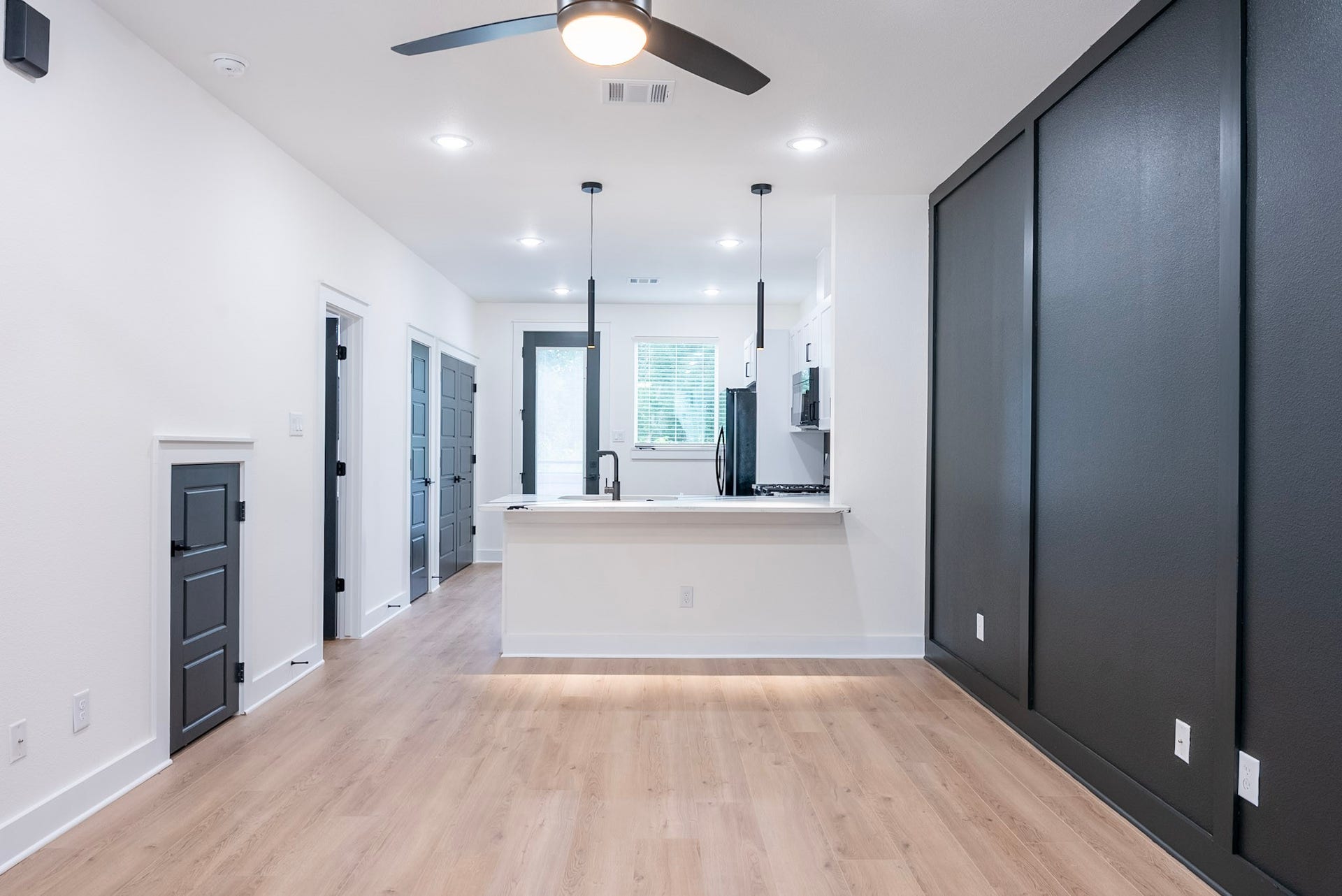 3522 Mansfield Building H Street, #C, Houston, TX 77091 Stylish open concept kitchen and living area featuring modern light fixtures, and warm wood flooring for a contemporary feel.