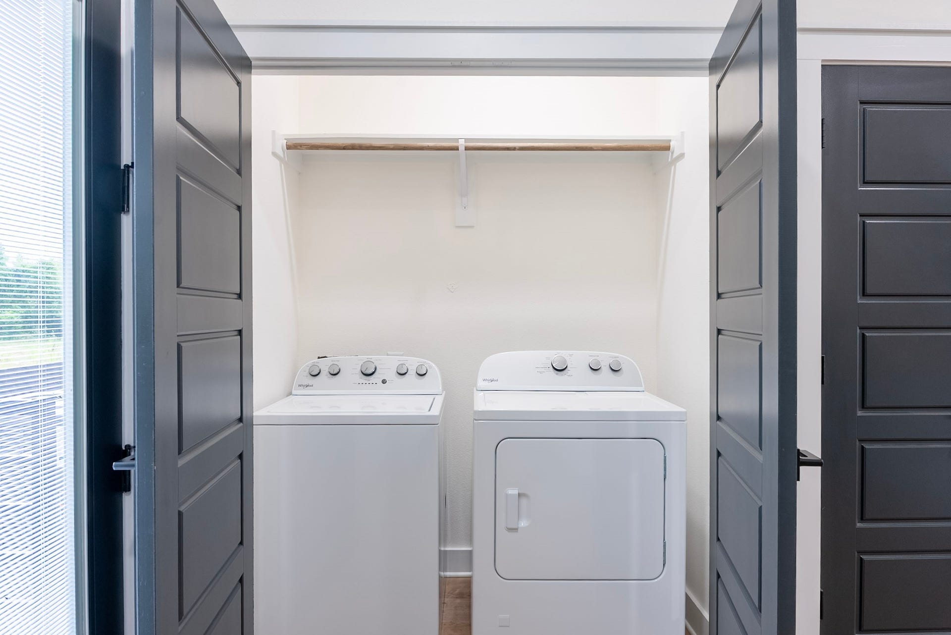 3522 Mansfield Building H Street, #C, Houston, TX 77091 Convenient laundry area with modern washer and dryer, tucked behind elegant double doors for a sleek and functional space.