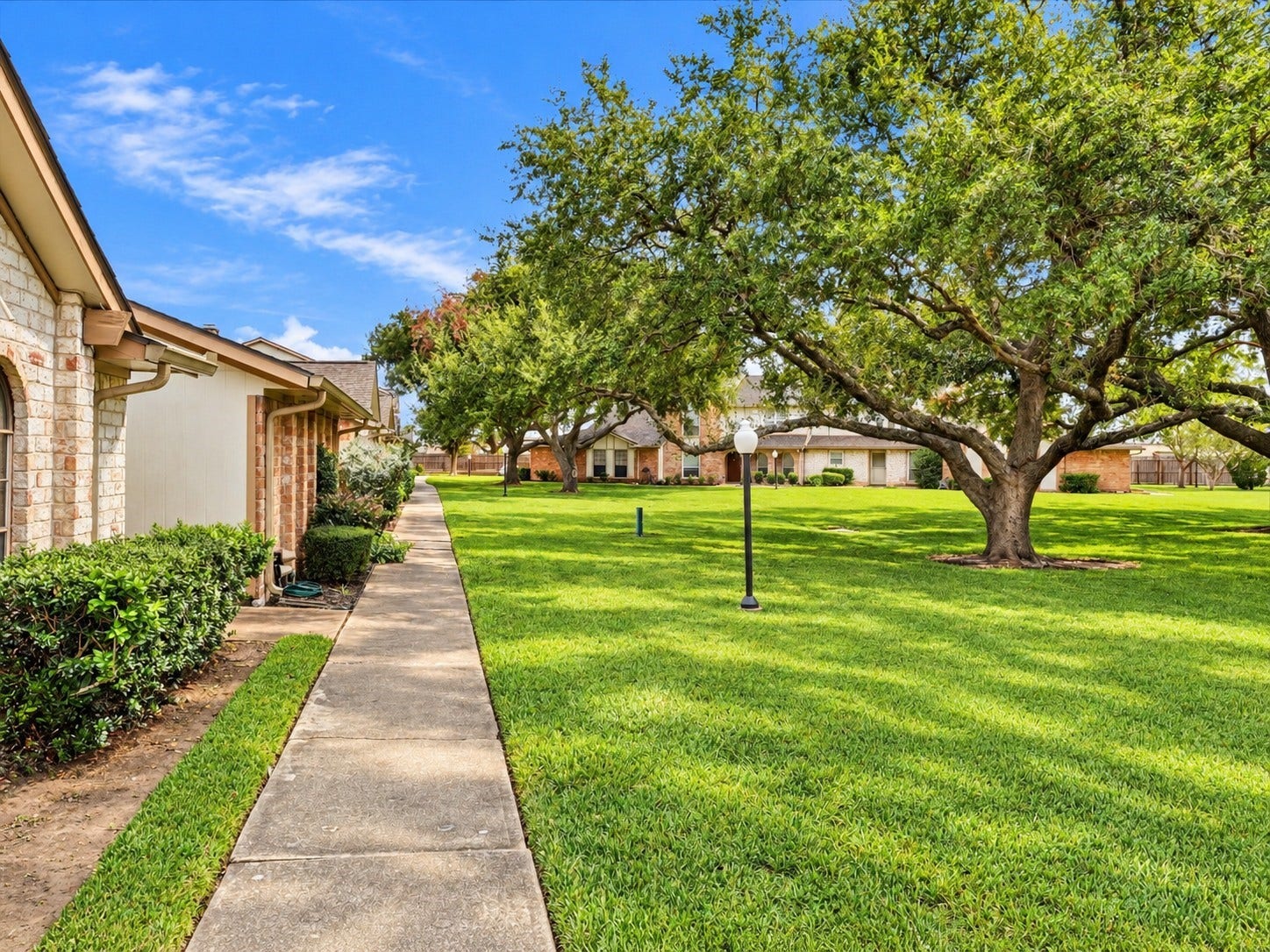 Enjoy the well maintained green space with mature shade trees outside your front door with a walkway to the pool or for a stroll.