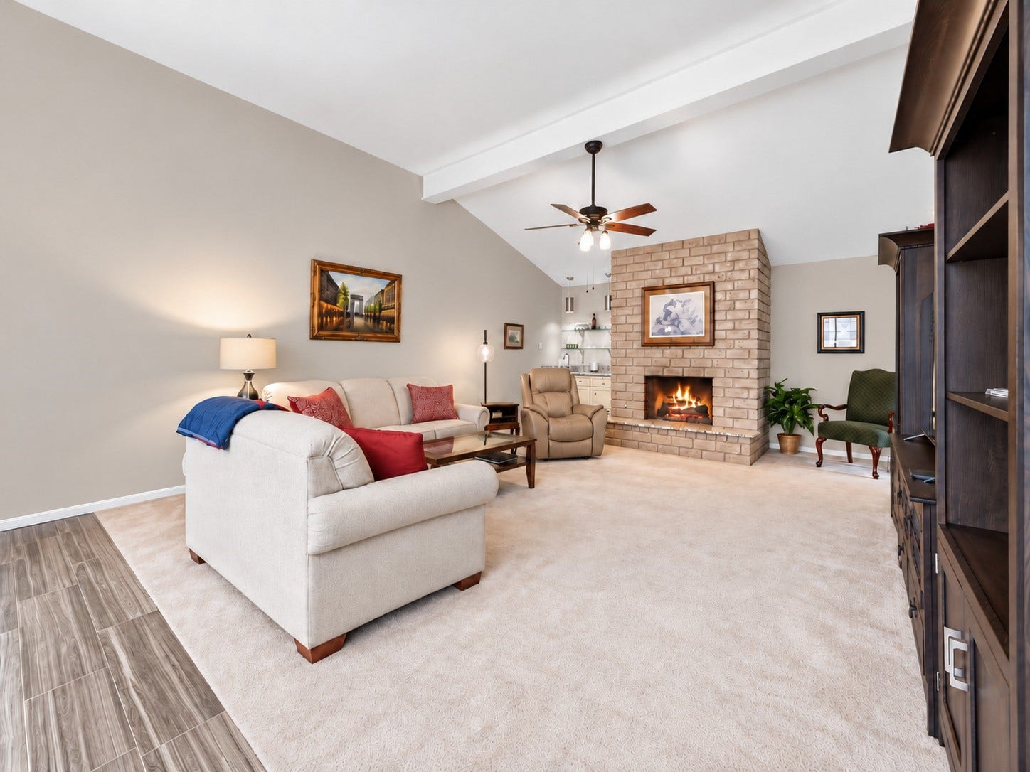 This spacious family room features comfy carpet, a gas log fireplace with brick surround & a granite topped hearth. Plus a wet bar with cabinet storage & glass display shelves.