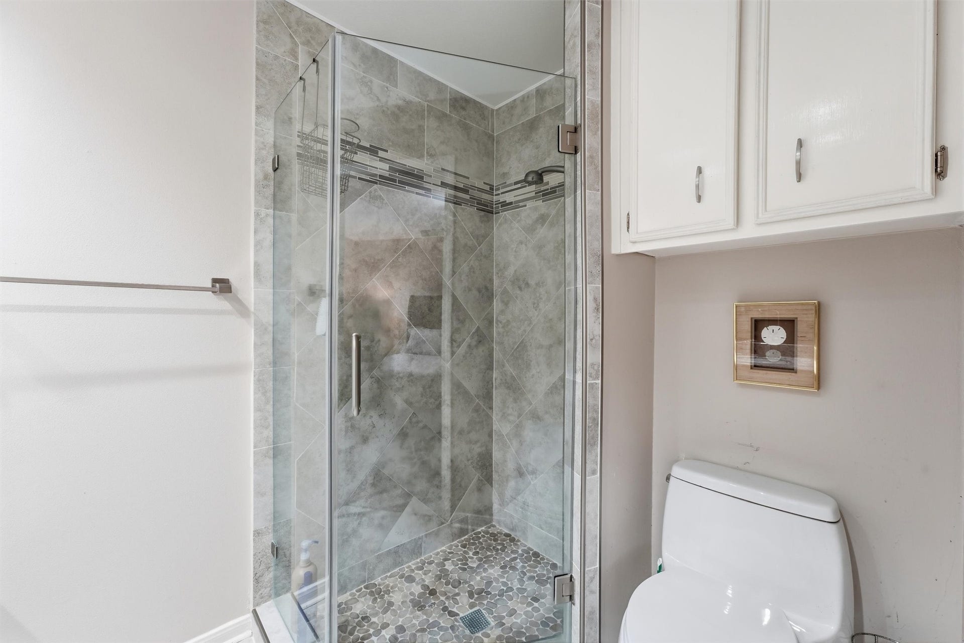 Corner shower has also been updated with frameless shower door, tile shower floor & floor to ceiling tiled walls.