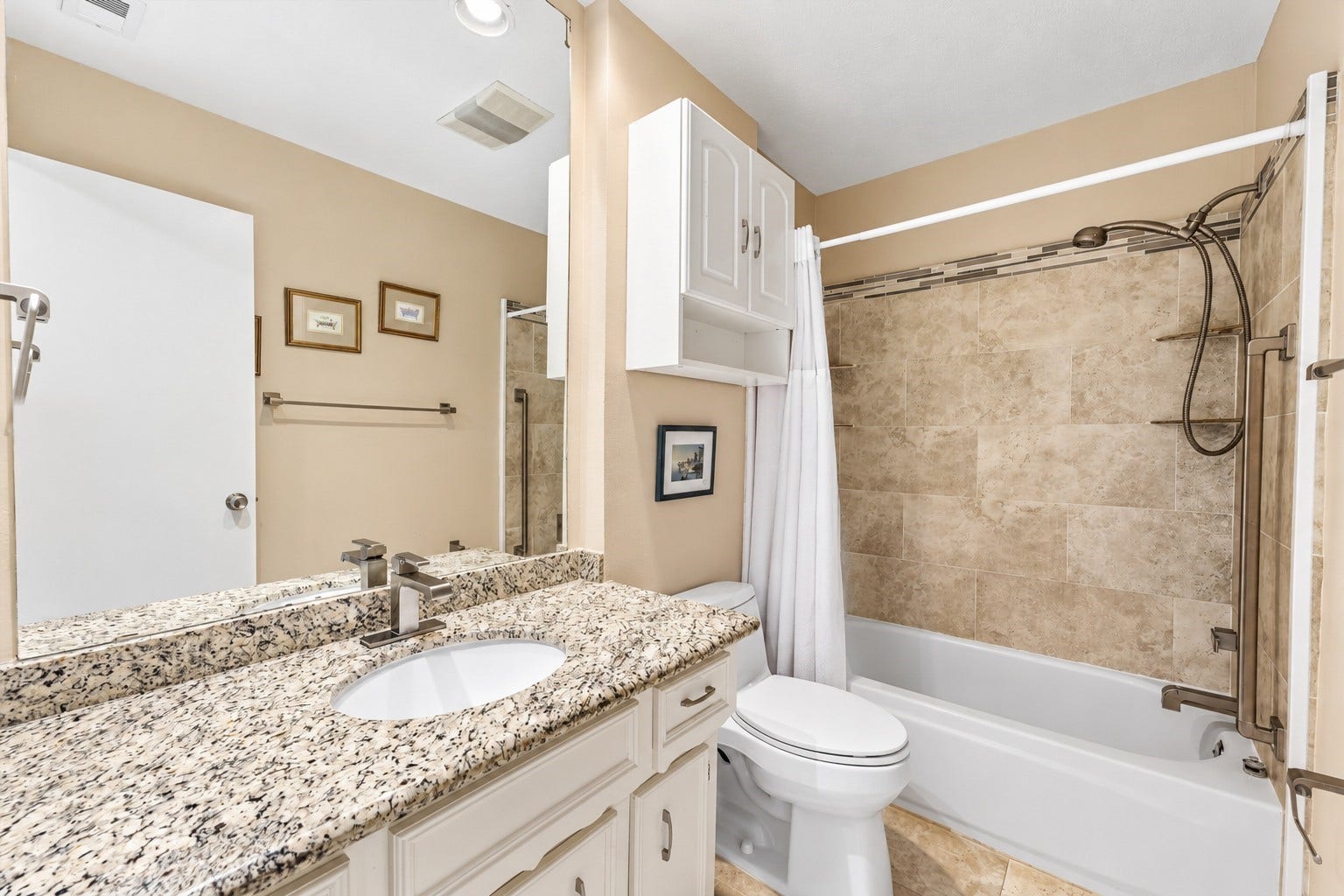 Secondary hall bath has been updated with granite counter, undermount sink, upgraded fixtures, tile flooring & tile bathtub surround.