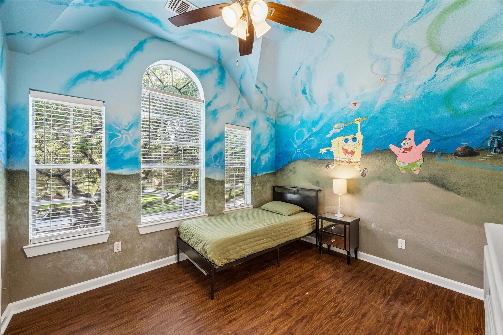 3615 Garrettsville Drive, Pearland, TX 77584 Vibrant bedroom featuring a playful underwater mural, vaulted ceilings, and ample natural light from arched windows, creating a cheerful and inviting space.