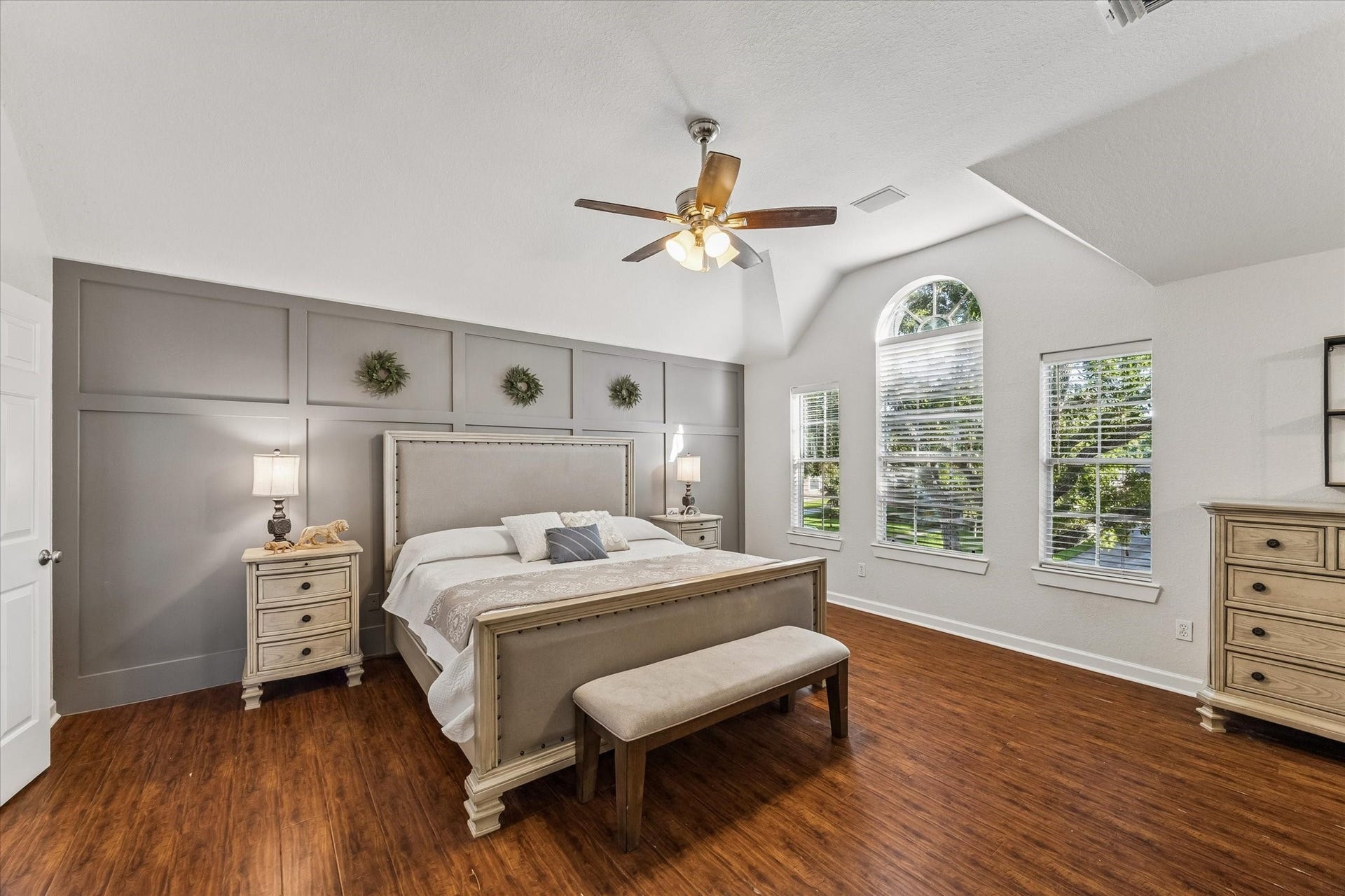 3615 Garrettsville Drive, Pearland, TX 77584 Spacious primary bedroom with an accent wall, large arched windows, and a separate sitting area.