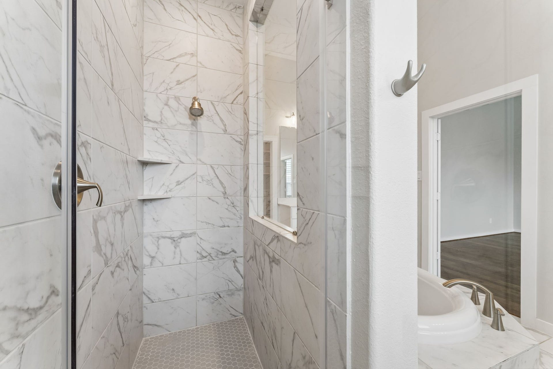 30410 Myrtle Oak Drive, Fulshear, TX 77423 This primary bathroom features a generously sized, luxurious walk-in shower designed with sophisticated, modern floor-to-ceiling tile work that creates a seamless and elegant aesthetic.