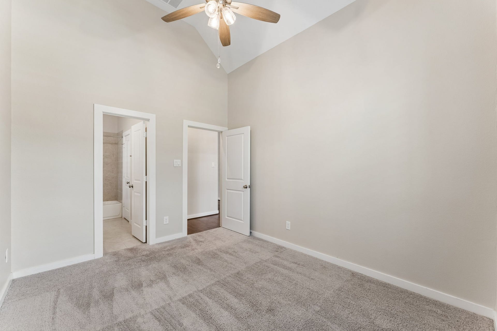 30410 Myrtle Oak Drive, Fulshear, TX 77423 Secondary bedroom at the front of the home offers high ceilings, plush carpet, a lighted ceiling fan and en-suite bath with a walk-in closet.