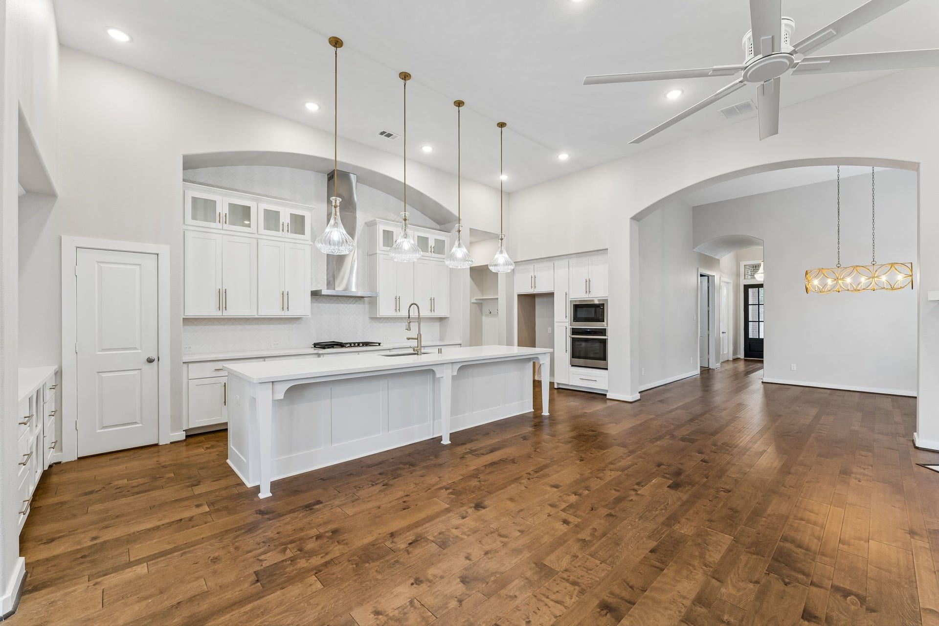 30410 Myrtle Oak Drive, Fulshear, TX 77423 This expansive, chef-inspired kitchen features a massive center island that serves as the heart of the home, complemented by custom cabinetry providing abundant storage space for all your culinary needs and kitchen essentials.