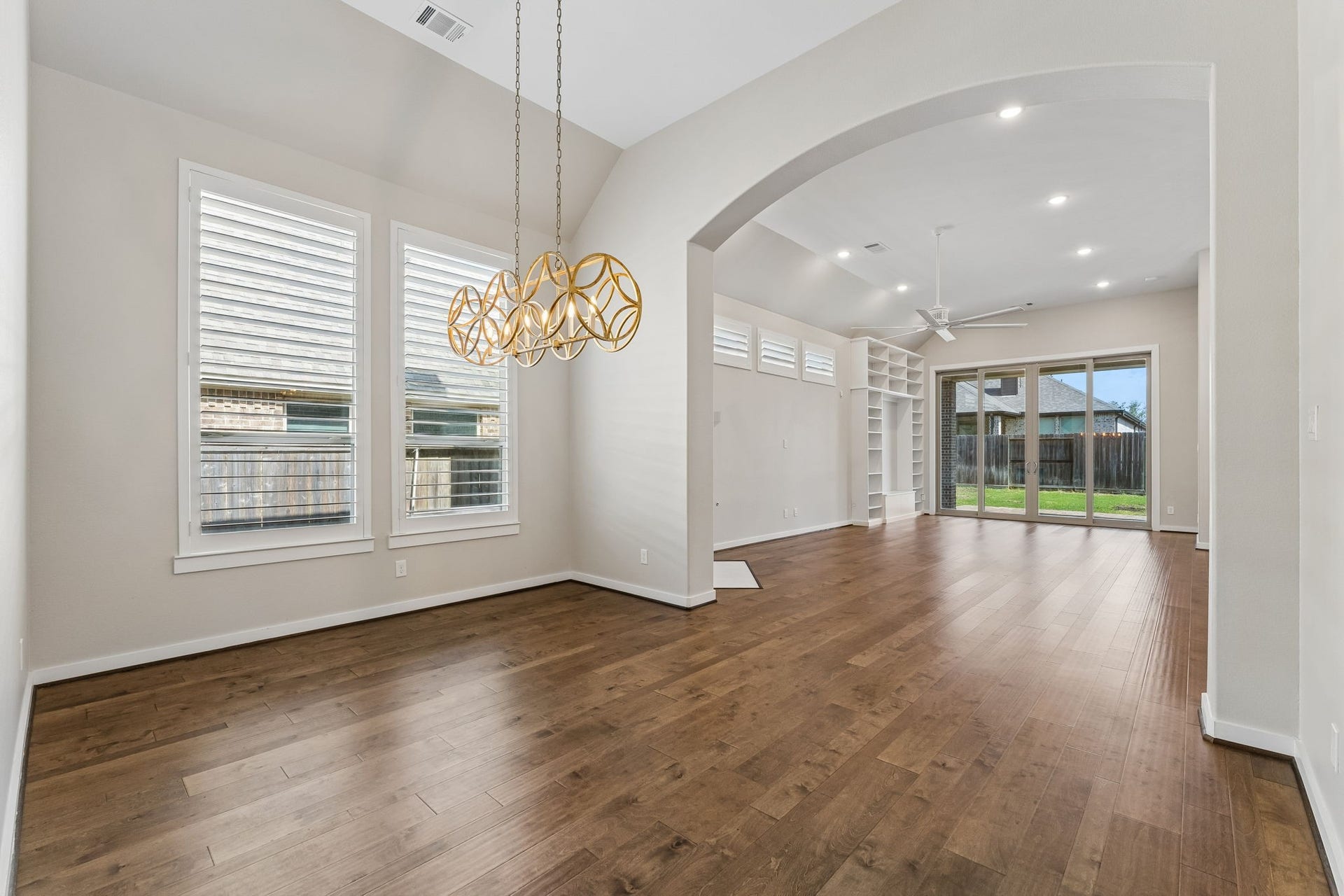 30410 Myrtle Oak Drive, Fulshear, TX 77423 This bright and formal dining room exudes an air of timeless sophistication, anchored by a stunning, high-end modern chandelier that serves as a dramatic focal point.