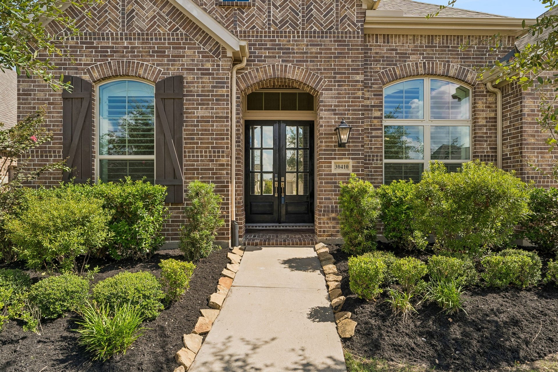 30410 Myrtle Oak Drive, Fulshear, TX 77423 Lovely entrance greets you with modern glass-paned solid wood door that adding elegance to the home's exterior.