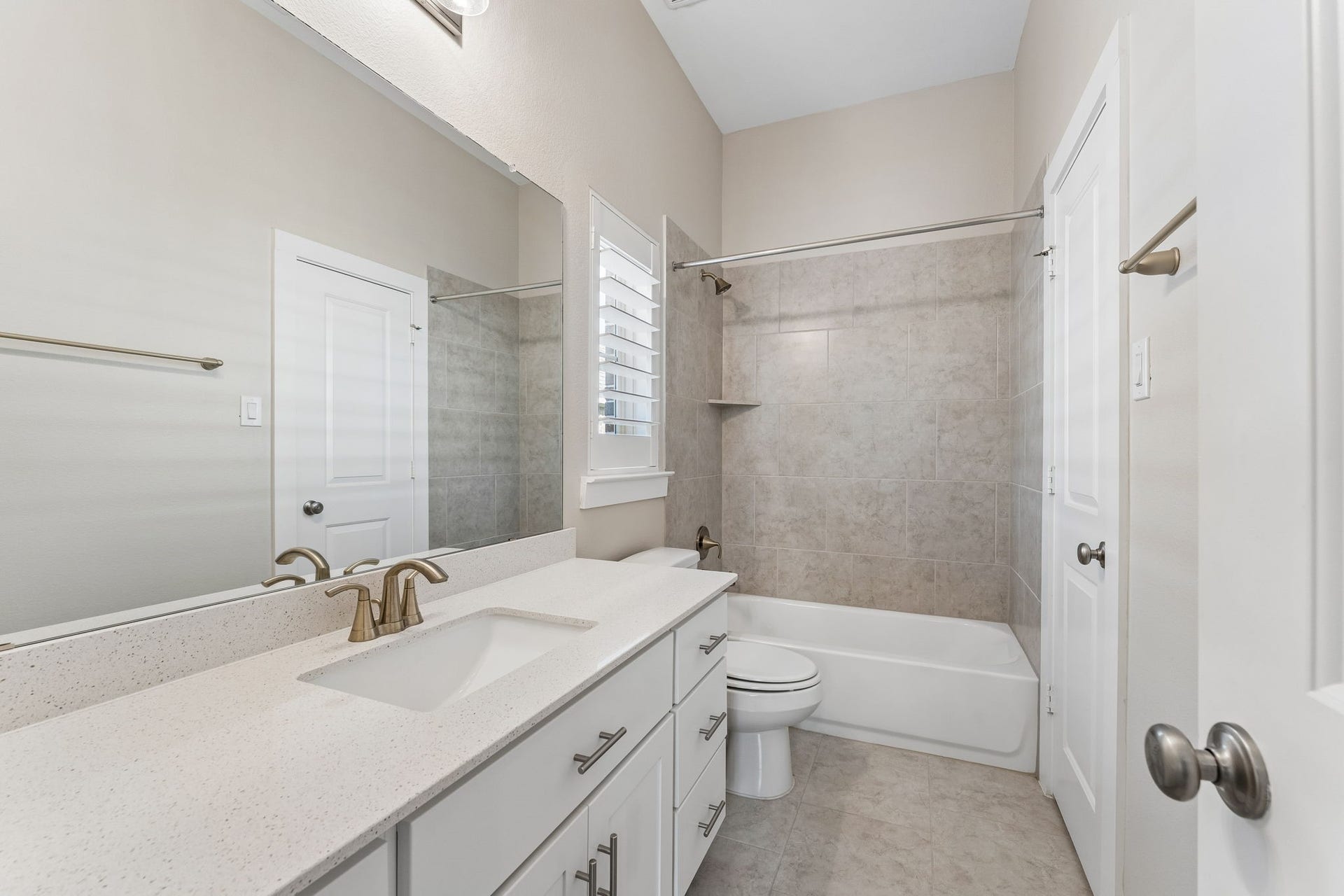 30410 Myrtle Oak Drive, Fulshear, TX 77423 Ensuite bath featuring extensive counter space, a tub/shower combo with an elegant tile surround, and a window that fills the room with natural light.