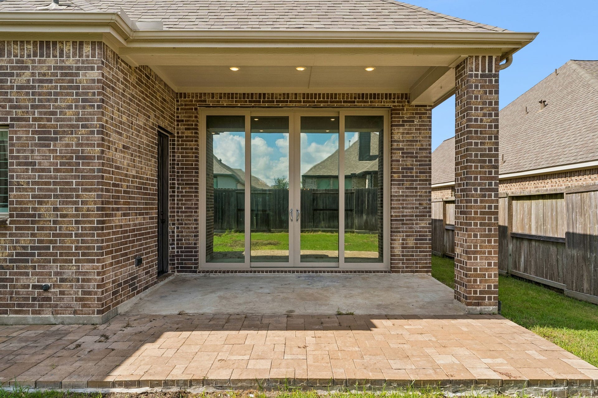 30410 Myrtle Oak Drive, Fulshear, TX 77423 Wonderful sliding doors bring the outside into the covered patio space with recessed lighting and extended pavers for added usability.