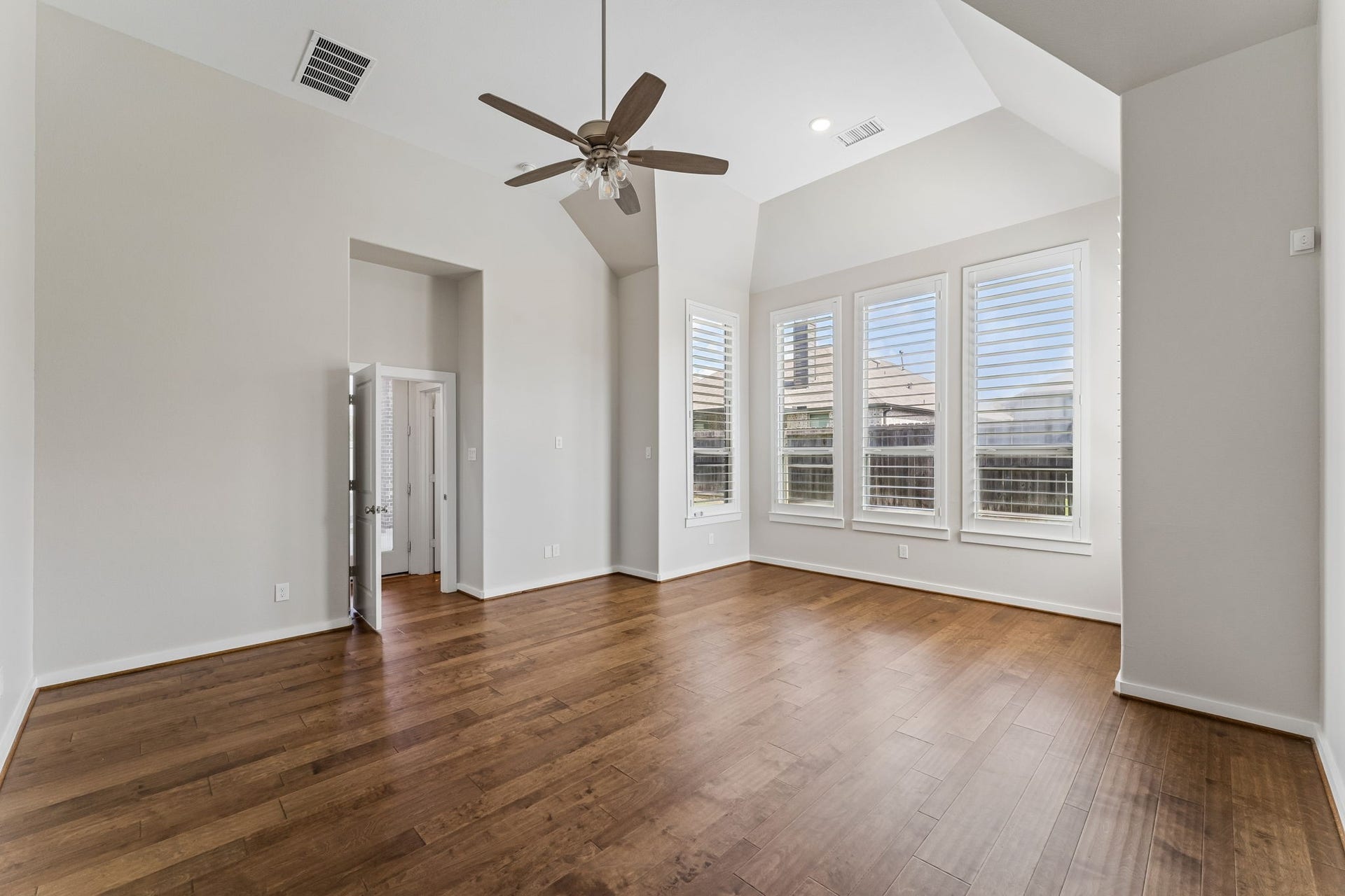 30410 Myrtle Oak Drive, Fulshear, TX 77423 The room is flooded with abundant natural light streaming through elegant plantation shutters, which offer both privacy and a sophisticated aesthetic. You will appreciate the warmth of the premium hardwood flooring underfoot, perfectly complemented by a cozy sitting area ideal for unwinding after a long day.