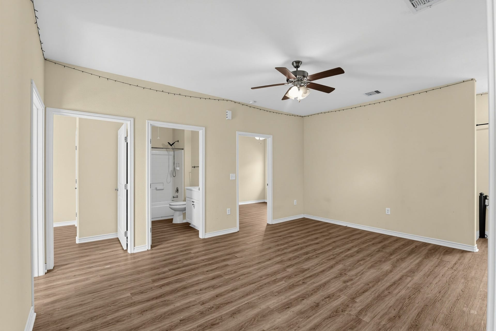 3717 Church Street Street, Galveston, TX 77550 The living room features a ceiling fan with a light fixture and extensive wood laminate flooring. Two bedrooms are located on either side of the full bathroom.
