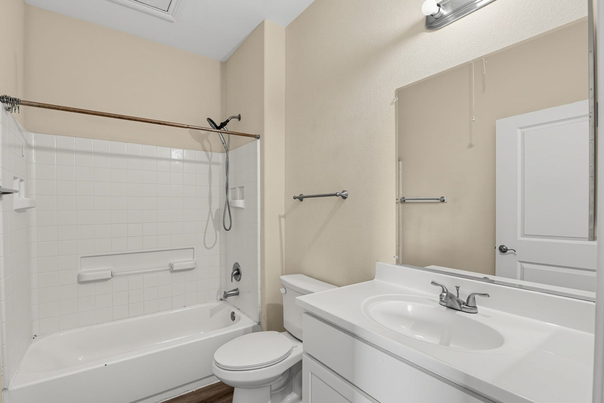 3717 Church Street Street, Galveston, TX 77550 The bathroom features a cultured marble vanity, an elongated commode, and a tile-enclosed tub and shower.