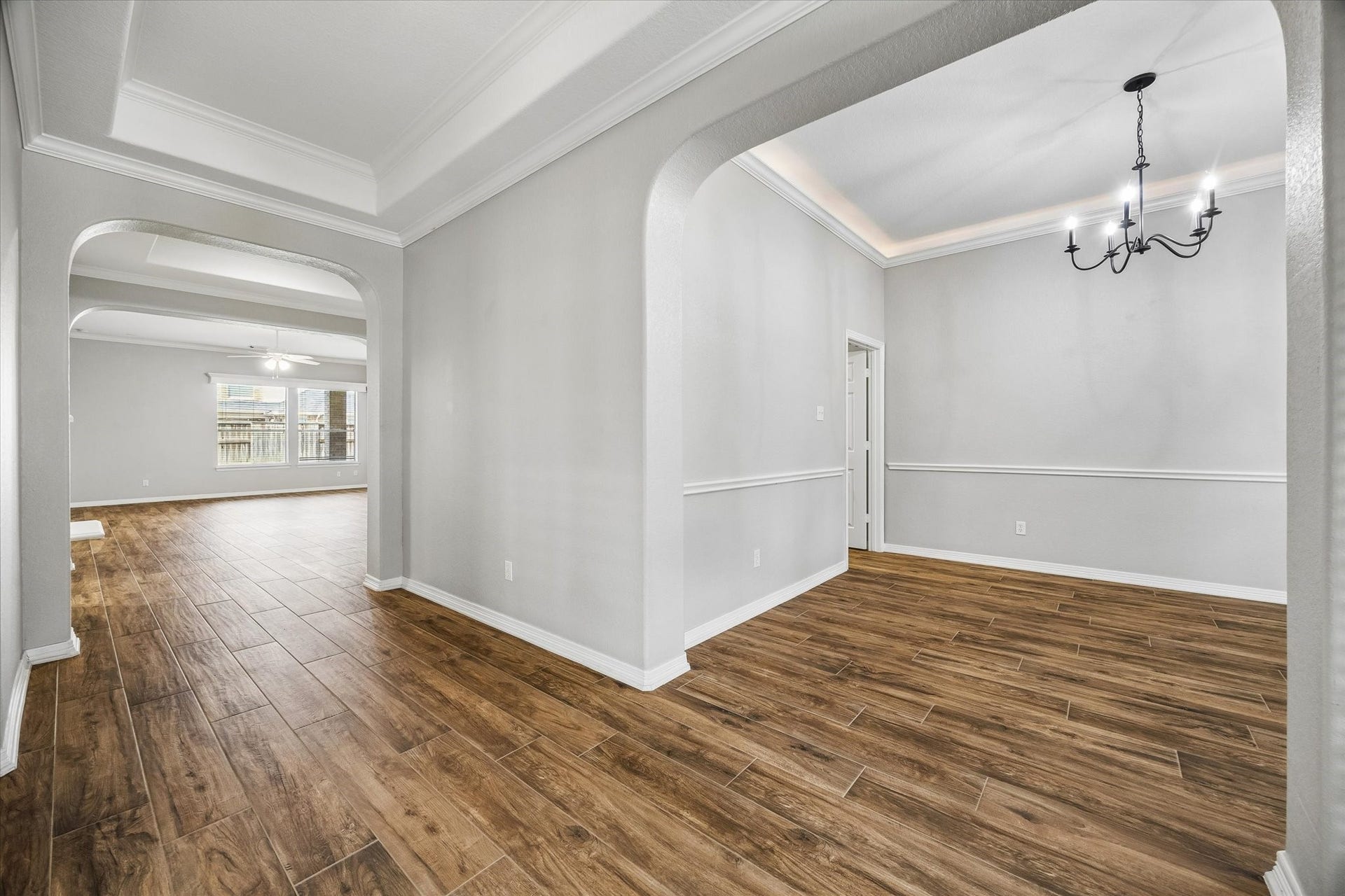 7715 BAYOU GREEN LANE, Sugar Land, TX 77479 OPEN-CONCEPT LAYOUT WITH ARCHITECTURAL DETAILS THROUGHOUT - ARCHED OPENINGS, WOOD-LOOK TILE FLOORING, AND A FORMAL DINING SPACE THAT FLOWS EASILY INTO THE MAIN LIVING AREAS.