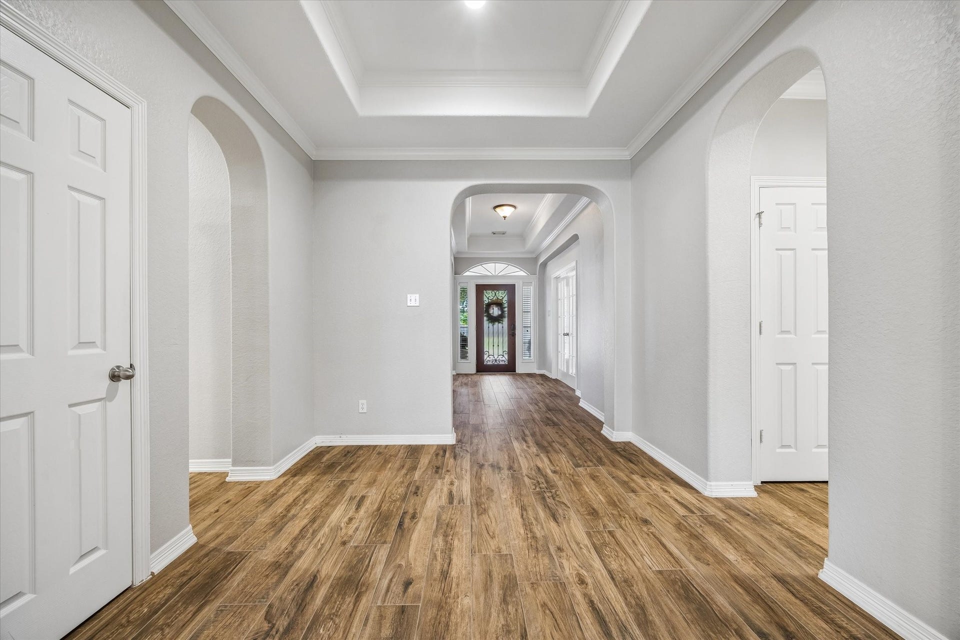 7715 BAYOU GREEN LANE, Sugar Land, TX 77479 FRESH, NEUTRAL INTERIORS FEATURE WOOD-LOOK FLOORING, ARCHED OPENINGS, CROWN MOLDING, AND A TRAY CEILING FOR A CLEAN, UPDATED FEEL.