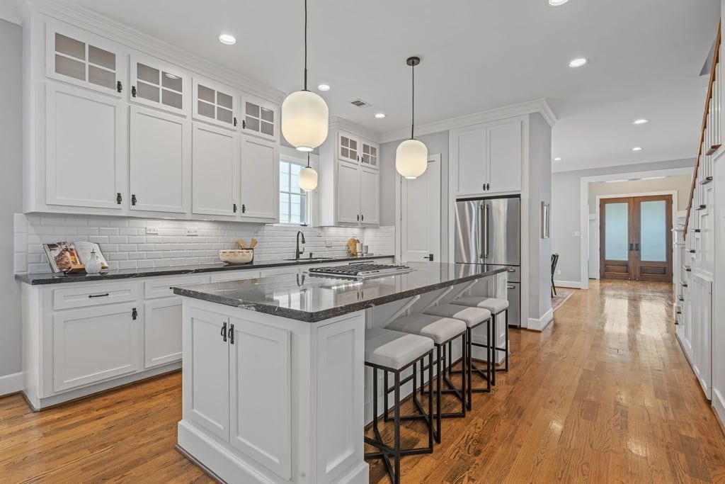 Classic white cabinetry, under-cabinet lighting, and generous counter space elevate the kitchen's functionality.