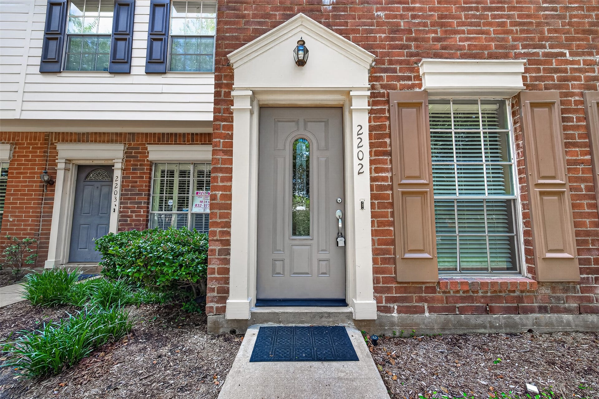 2930 Grants Lake Boulevard, #2202, Sugar Land, TX 77479 Welcoming private entrance framed by brick exterior, decorative trim, and mature landscaping.