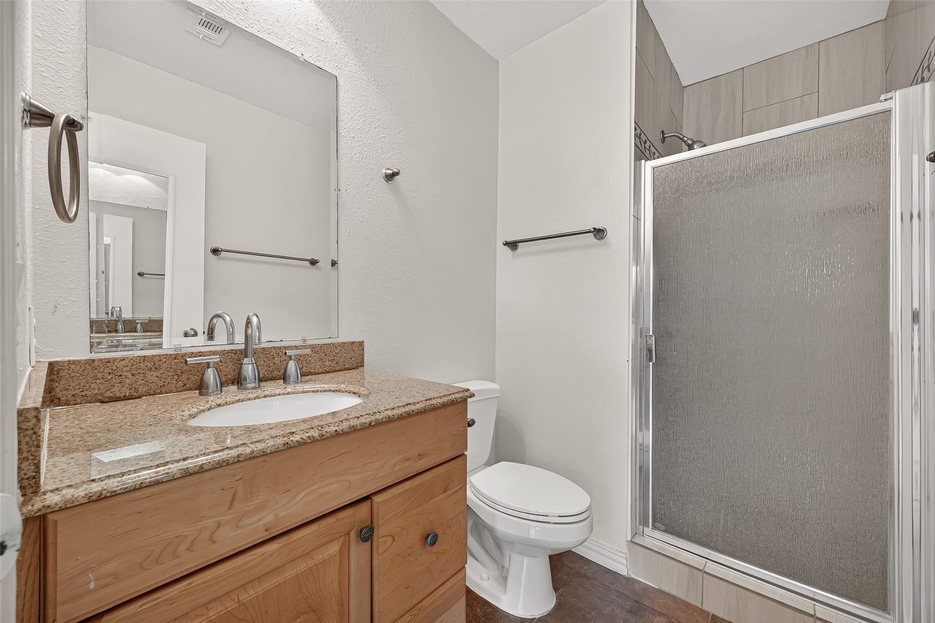 2930 Grants Lake Boulevard, #2202, Sugar Land, TX 77479 En-suite primary bath featuring granite countertop vanity and tiled shower with glass enclosure.