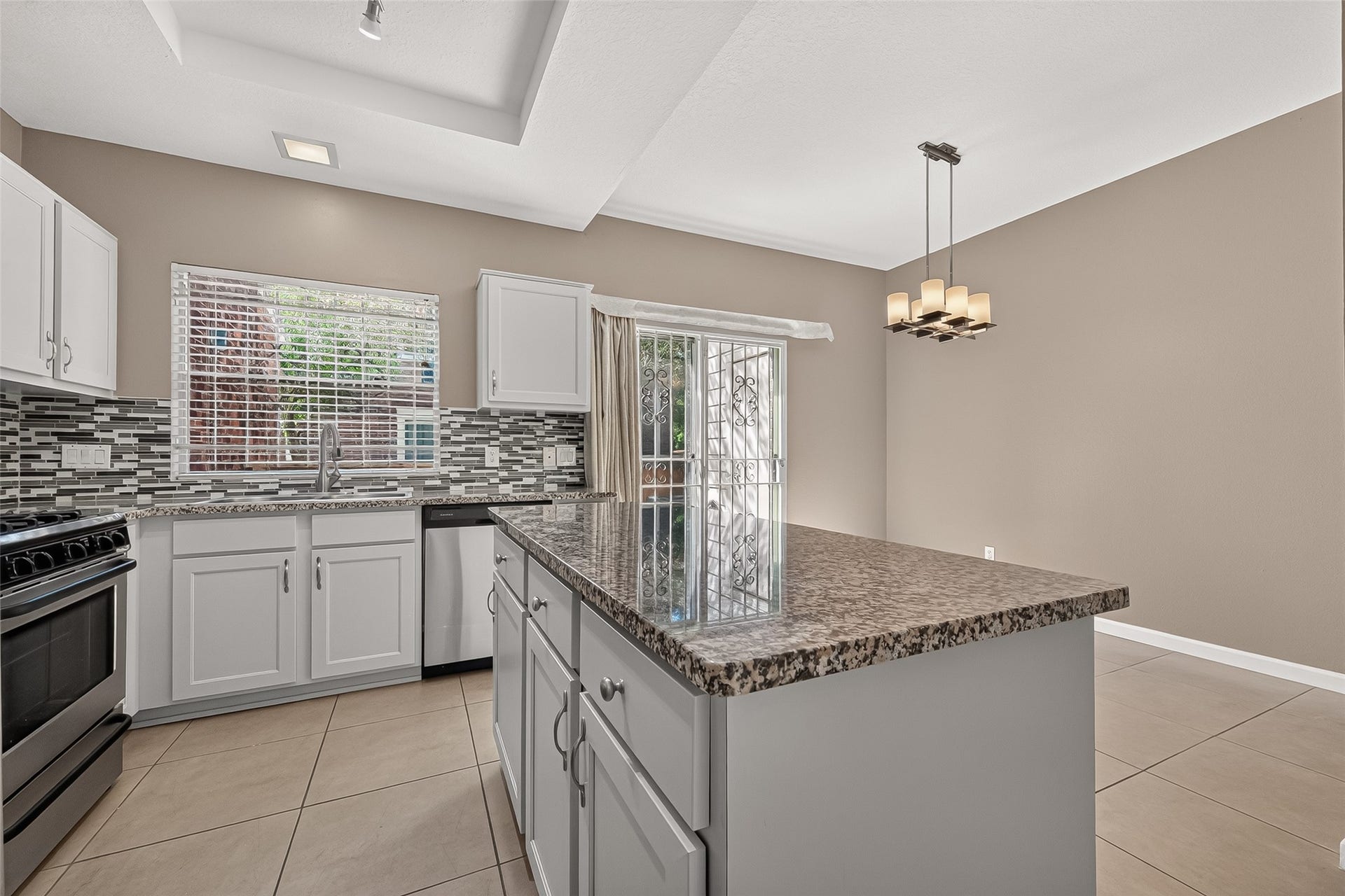 2930 Grants Lake Boulevard, #2202, Sugar Land, TX 77479 Well-appointed kitchen showcasing granite countertops, stainless-steel appliances, decorative backsplash, abundant cabinetry, and convenient island workspace.