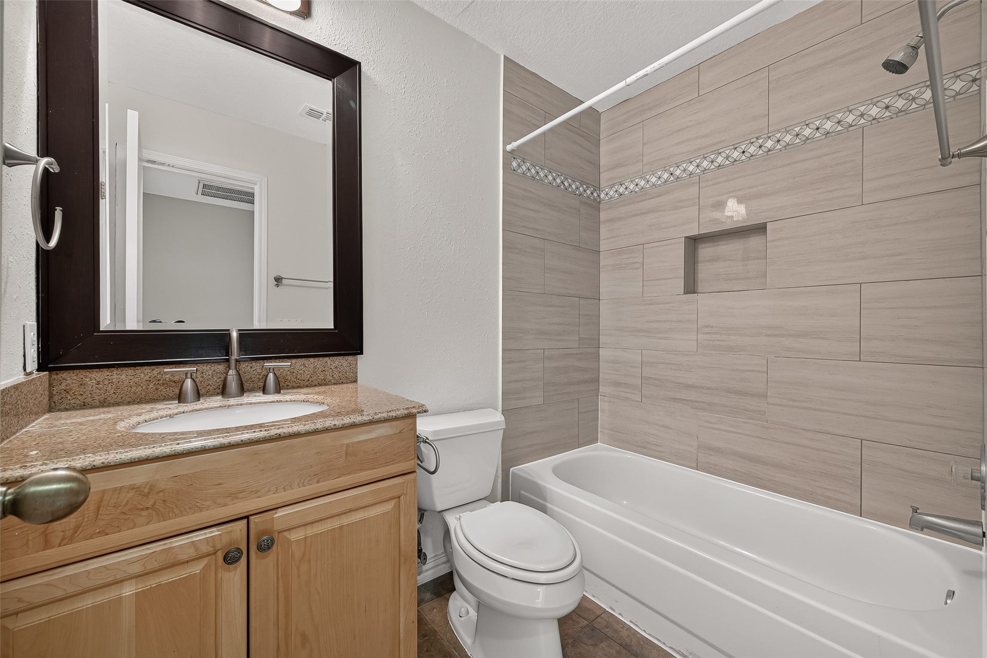 2930 Grants Lake Boulevard, #2202, Sugar Land, TX 77479 The guest bath has full bath featuring granite countertop vanity, tub/shower combination, large-format tile surround, decorative accent detailing, and built-in shower niche.