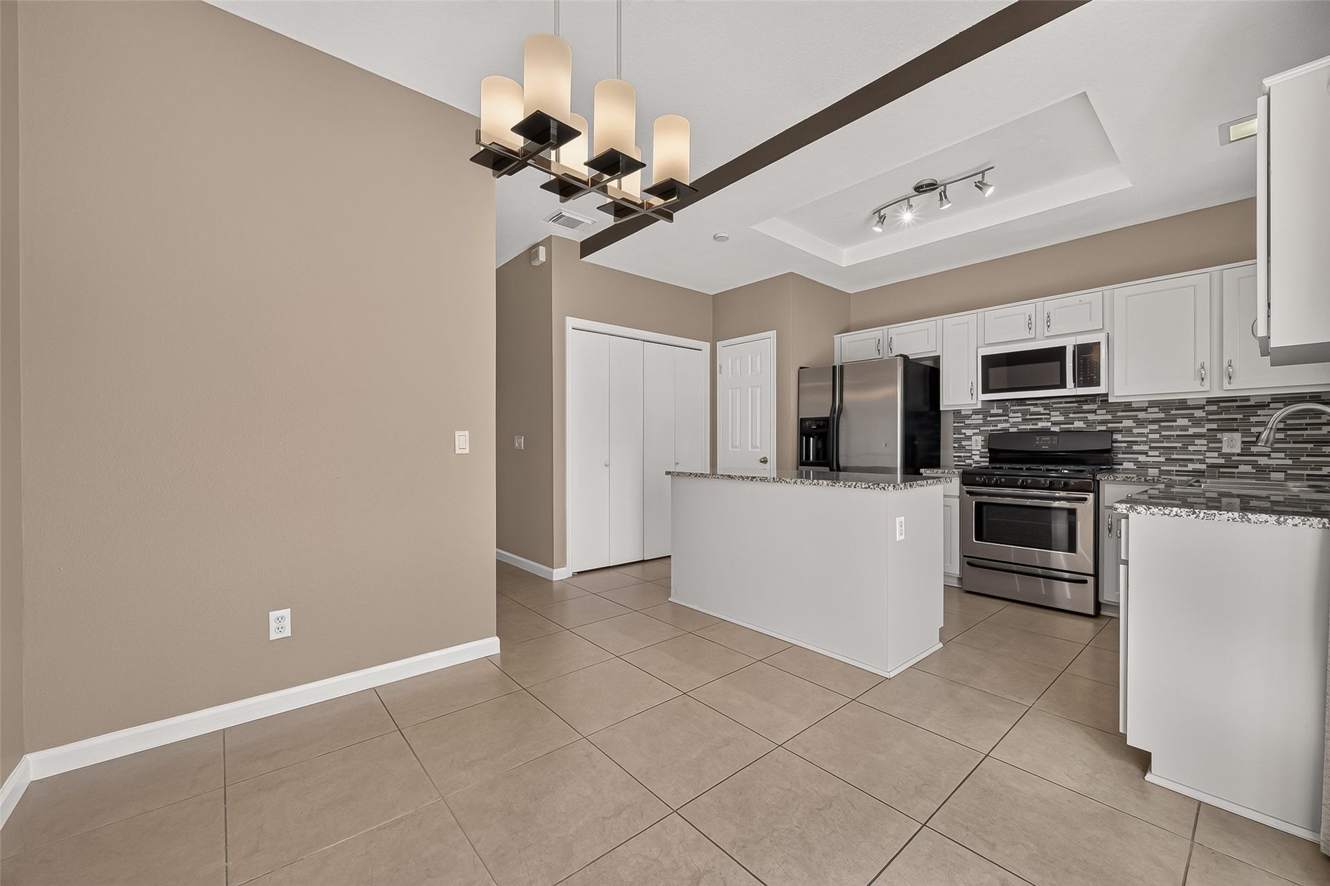 2930 Grants Lake Boulevard, #2202, Sugar Land, TX 77479 Spacious kitchen and dining combination offering granite countertops, stainless-steel appliances, decorative backsplash, abundant cabinetry, and an open layout ideal for everyday living.