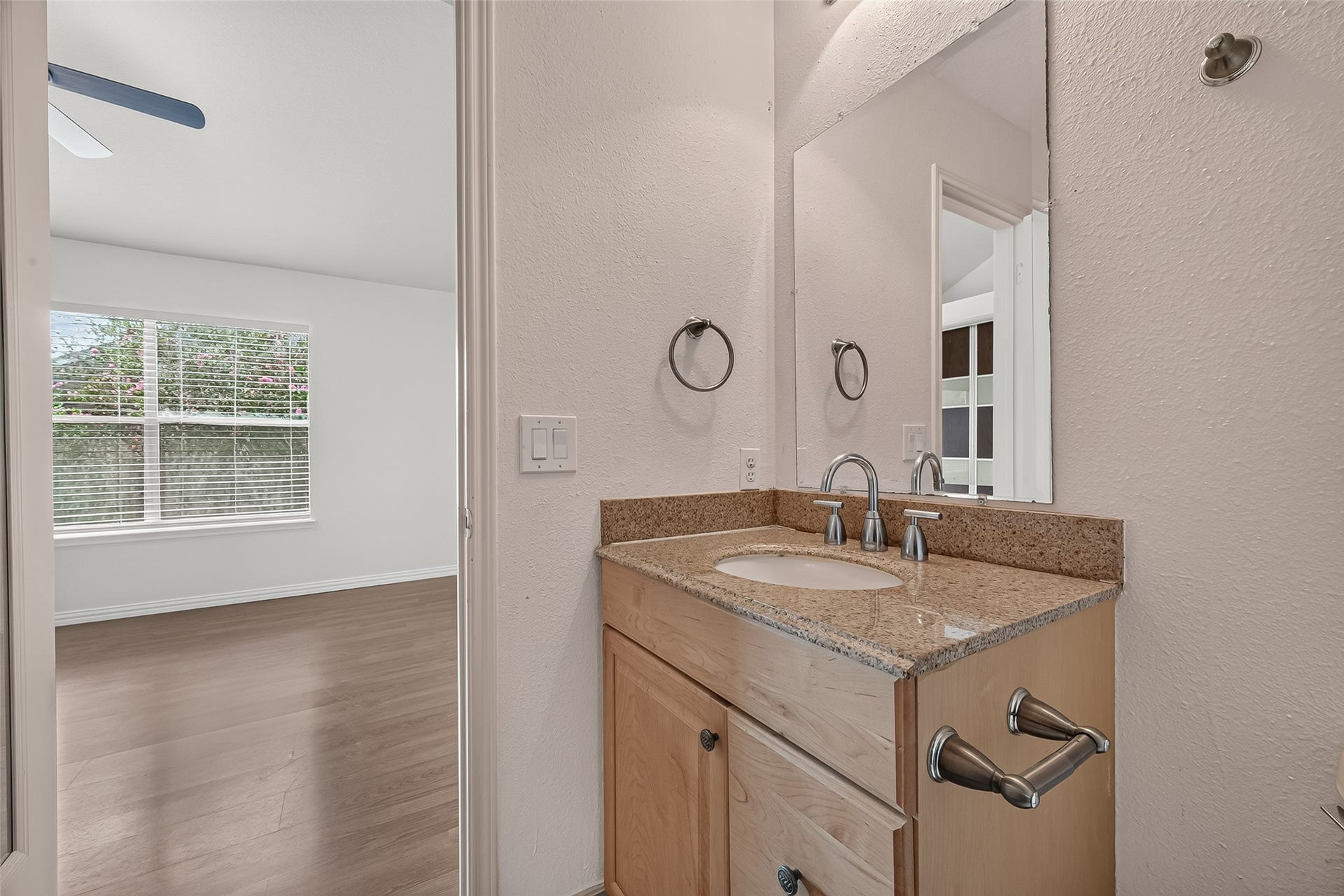 2930 Grants Lake Boulevard, #2202, Sugar Land, TX 77479 En-suite primary bath featuring granite countertop vanity, contemporary fixtures, large mirror, and convenient access from the spacious primary bedroom.