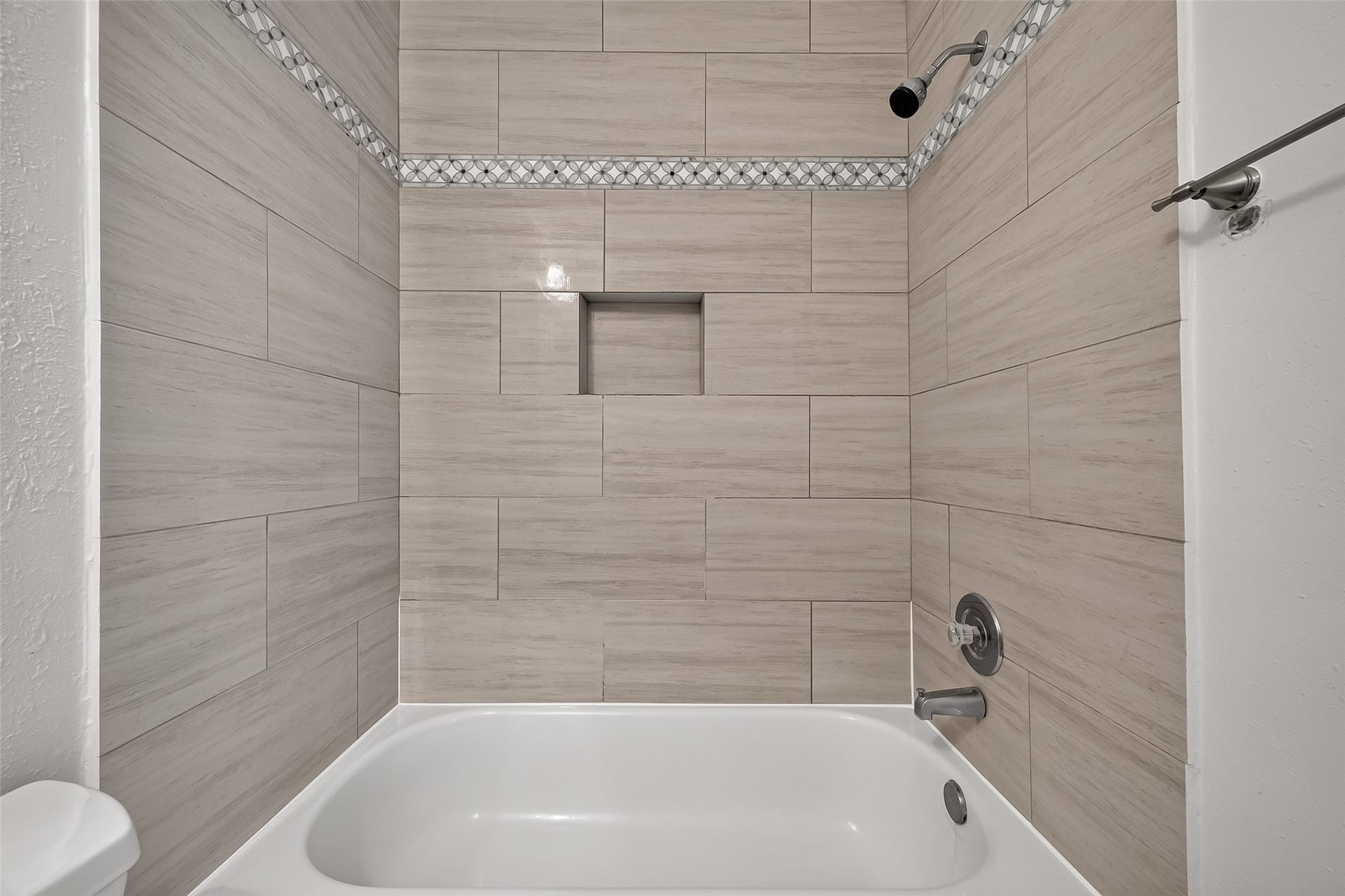 2930 Grants Lake Boulevard, #2202, Sugar Land, TX 77479 Attractive tub/shower combination surrounded by large-format tile with decorative accent border and convenient built-in shower niche.