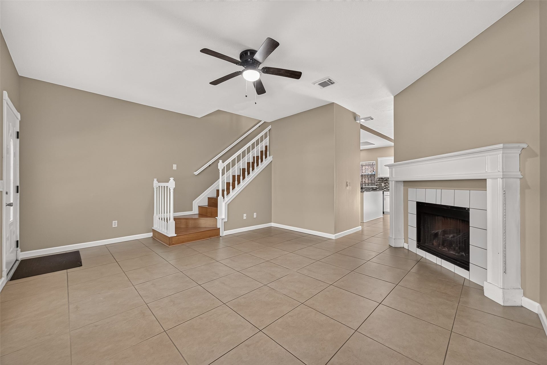 2930 Grants Lake Boulevard, #2202, Sugar Land, TX 77479 Open living area with fireplace, neutral finishes, tile flooring, and easy flow toward the kitchen and staircase.