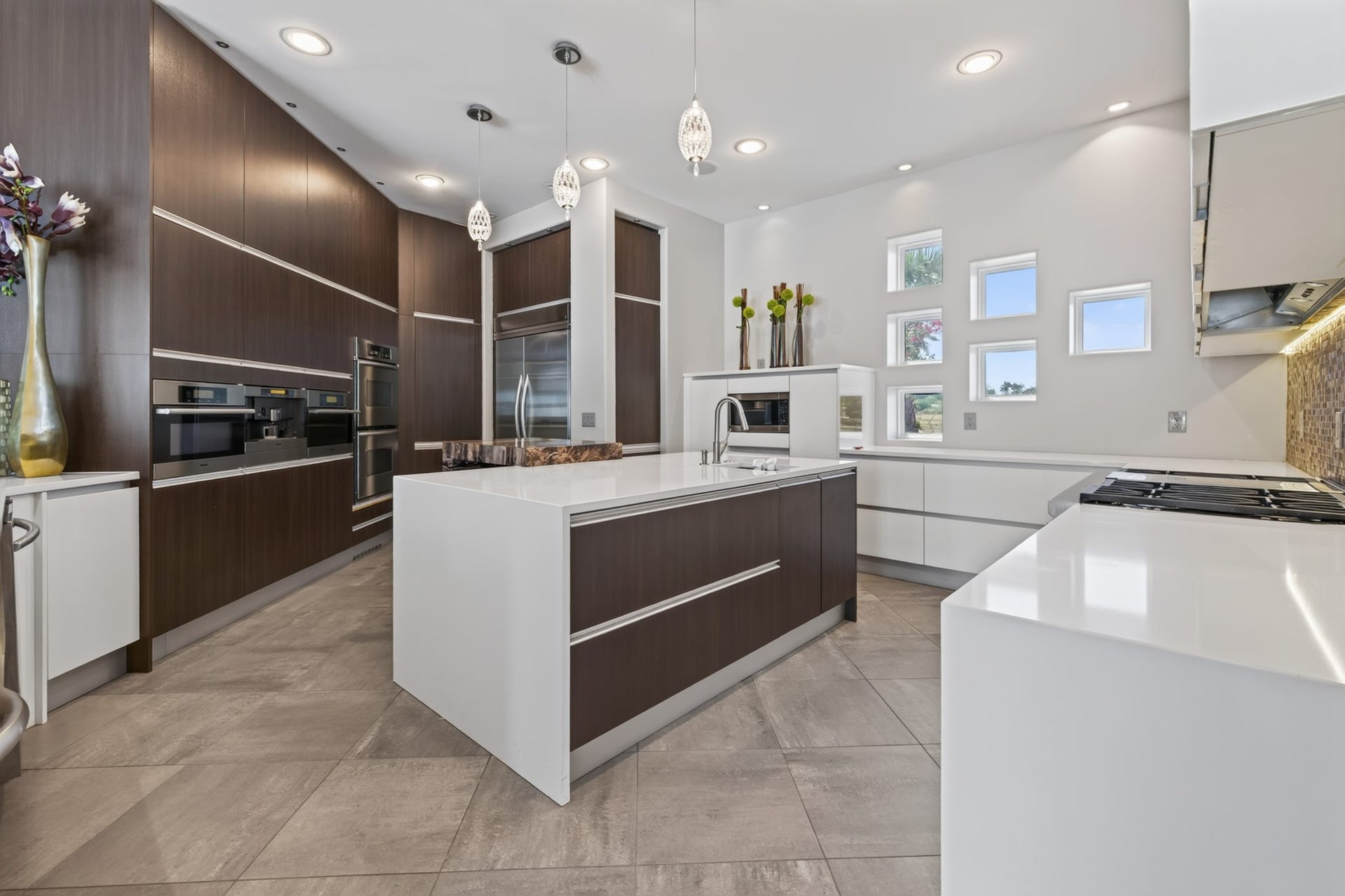 Showpiece kitchen pairs sleek custom cabinetry with dramatic stone surfaces and generous entertaining space.